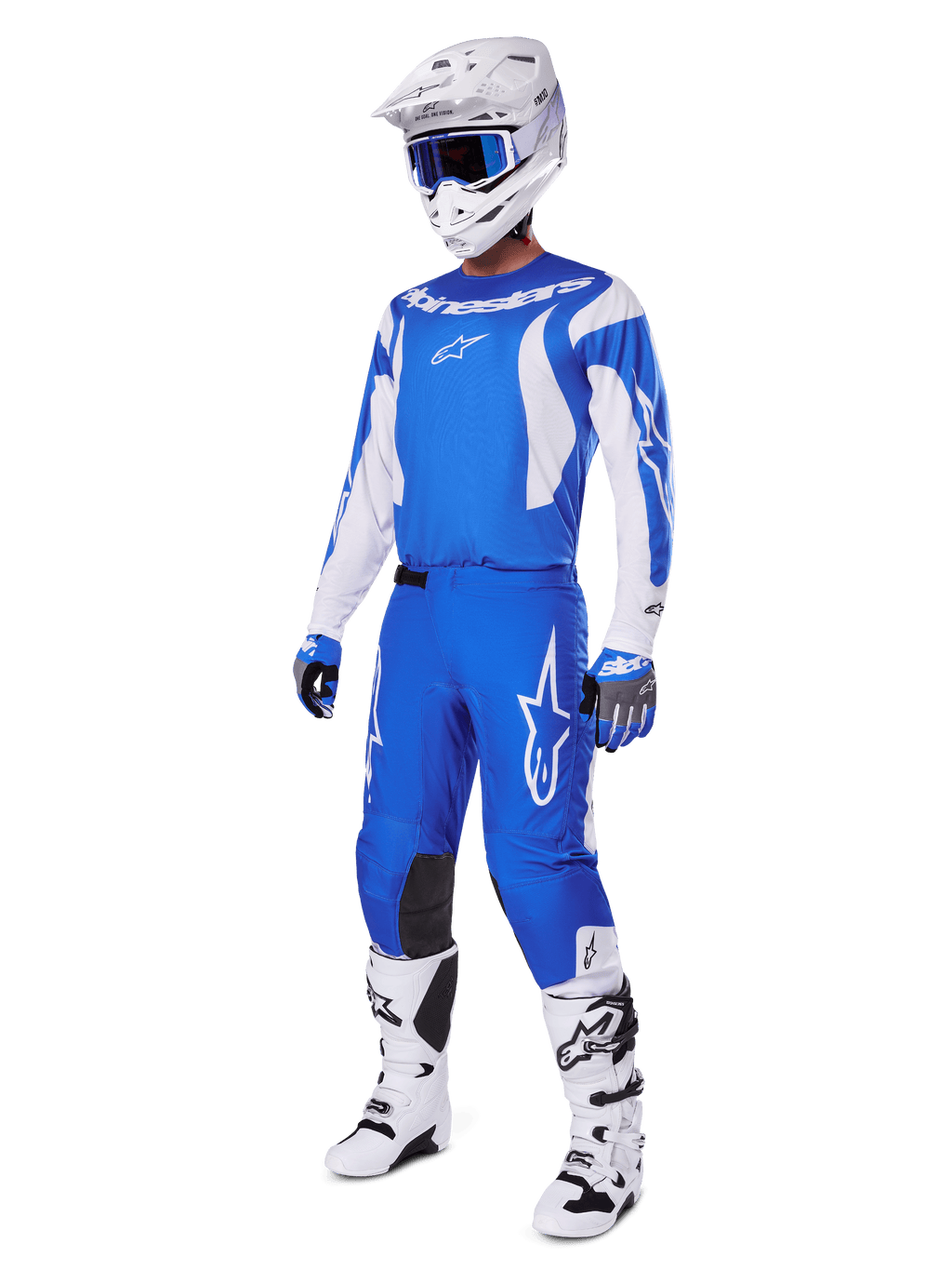 Motorcrosser die de volledige 2025 Fluid Haul Gear Set draagt, blauwe en witte jersey en broek met Alpinestars-branding, witte helm met blauwe bril, witte laarzen en blauwe handschoenen, gecoördineerde race-outfit voor off-road motorcross.