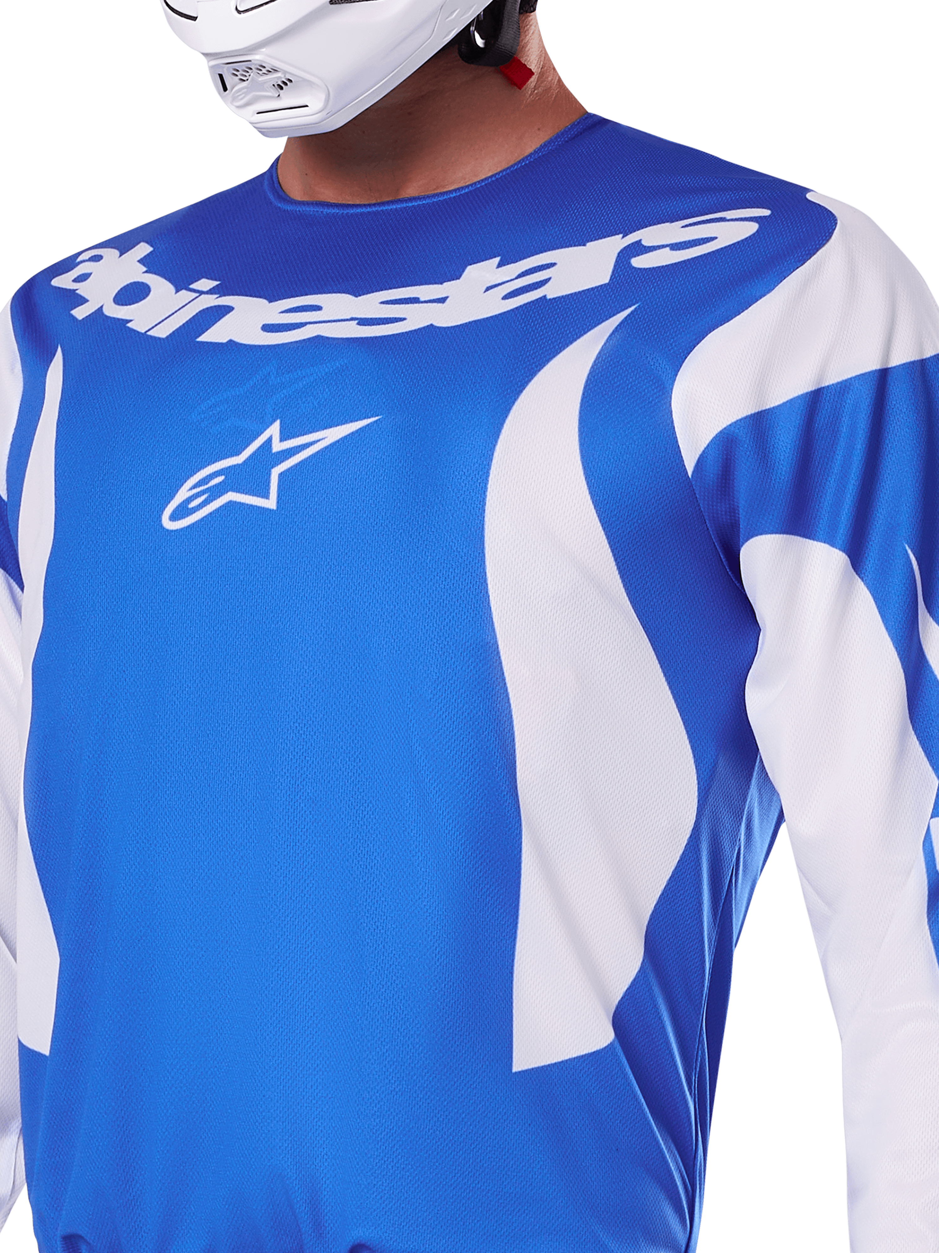 Alpinestars 2025 Fluid Haul Jersey, blauw en wit, gedragen door een rijder met een witte helm, voorzien van een wit Alpinestars-woordmerk en A-star logo, atletische pasvorm, lichtgewicht vochtafvoerend materiaal voor motorcross en off-road rijden