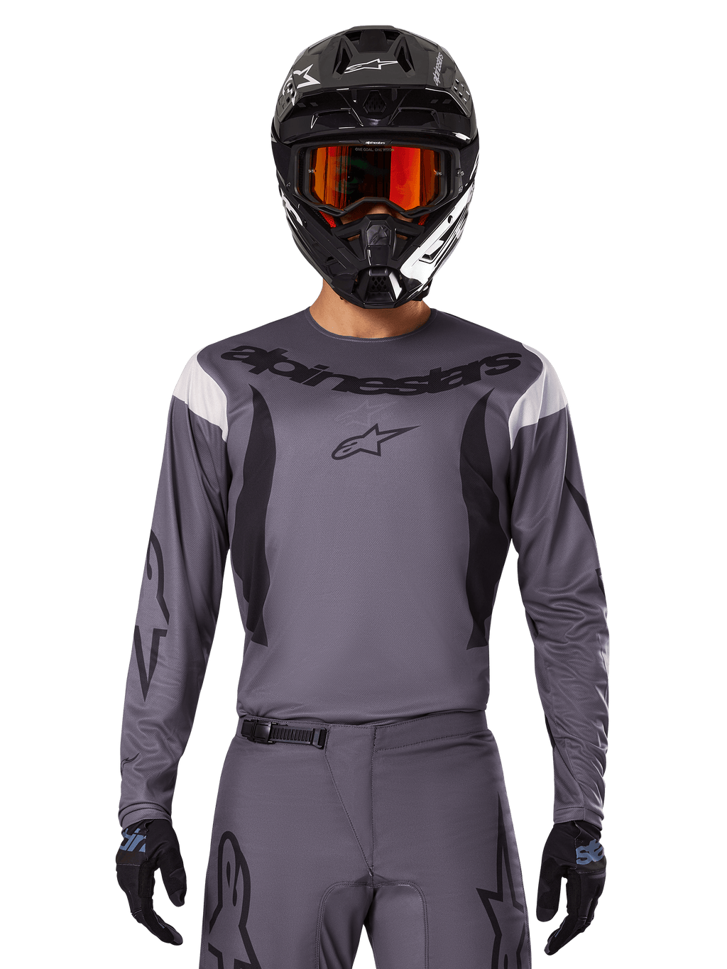 Alpinestars 2025 Fluid Haul Jersey en Gear Set, motorcross outfit, grijs met zwarte en witte accenten, lange mouwen en opvallende branding, zwarte helm met oranje bril en zwarte handschoenen, compleet tenue voor off-road racen