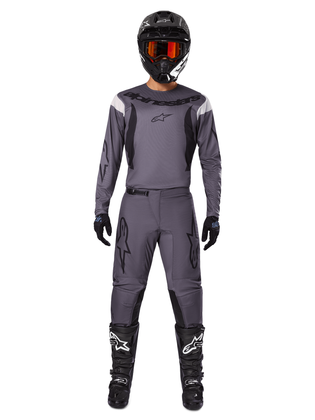 Alpinestars 2025 Fluid Haul Gear Set, motorcross uitrusting, grijs, grijze jersey en broek met zwarte accenten, zwarte helm met oranje bril, zwarte laarzen met witte logo's, gecoördineerde race-outfit voor off-road prestaties