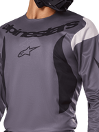 Alpinestars 2025 Fluid Haul Jersey, motorcross shirt, grijs met zwarte en witte accenten, voorzien van het Alpinestars-logo en woordmerk op de borst, sportieve pasvorm voor off-road racen
