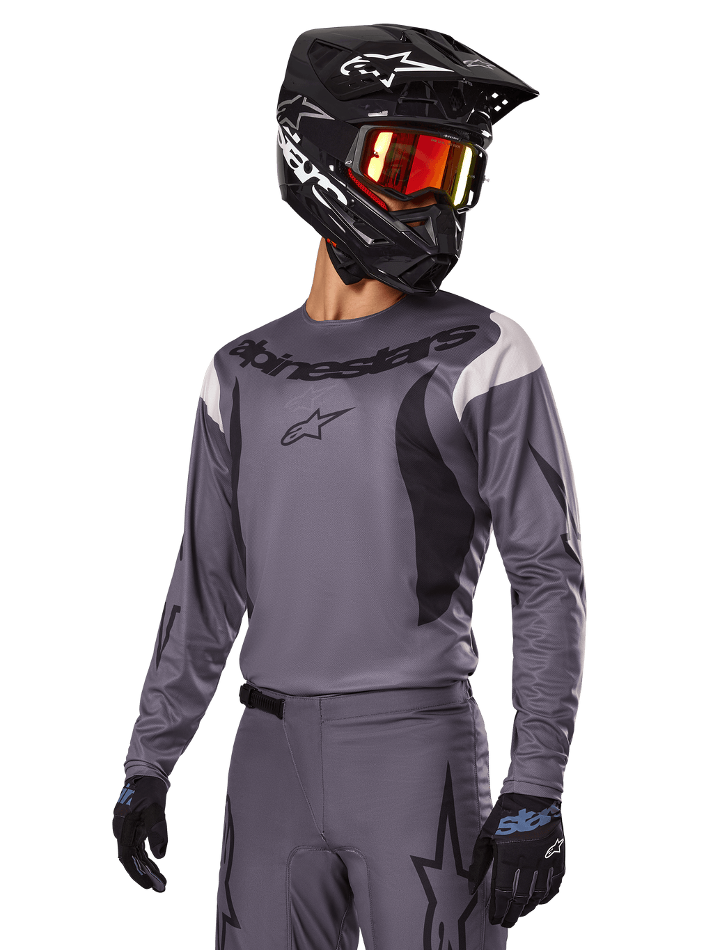 Alpinestars 2025 Fluid Haul Gear Set, grijs motorcross shirt en broek met zwarte en witte accenten, gedragen met een zwarte helm, rode crossbril en zwarte handschoenen, sportieve pasvorm voor off-road rijden