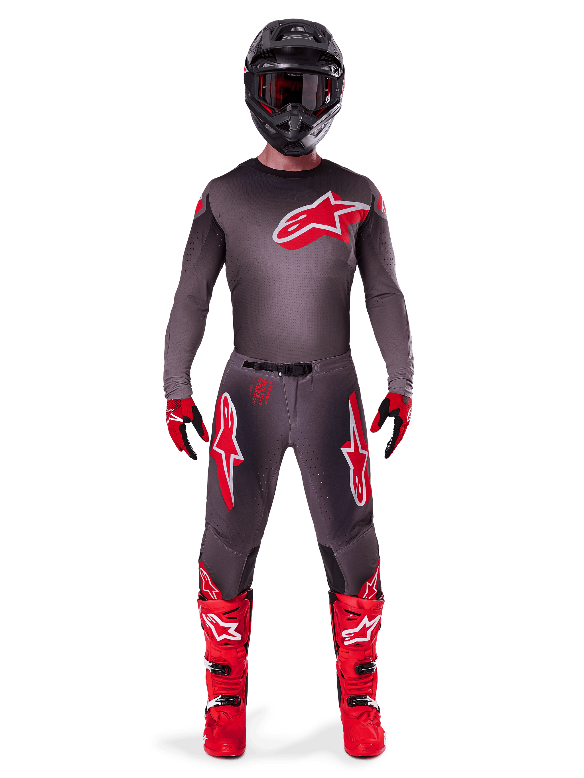 Motorcrosser in volledige race-uitrusting, Alpinestars 2025 Supertech Lipan Jersey in Smoke Bright Red, bijpassende grijze broek met rode logo's, felrode laarzen, zwarte helm met motorcrossbril en rood-zwarte handschoenen, professionele motorcrossoutfit.