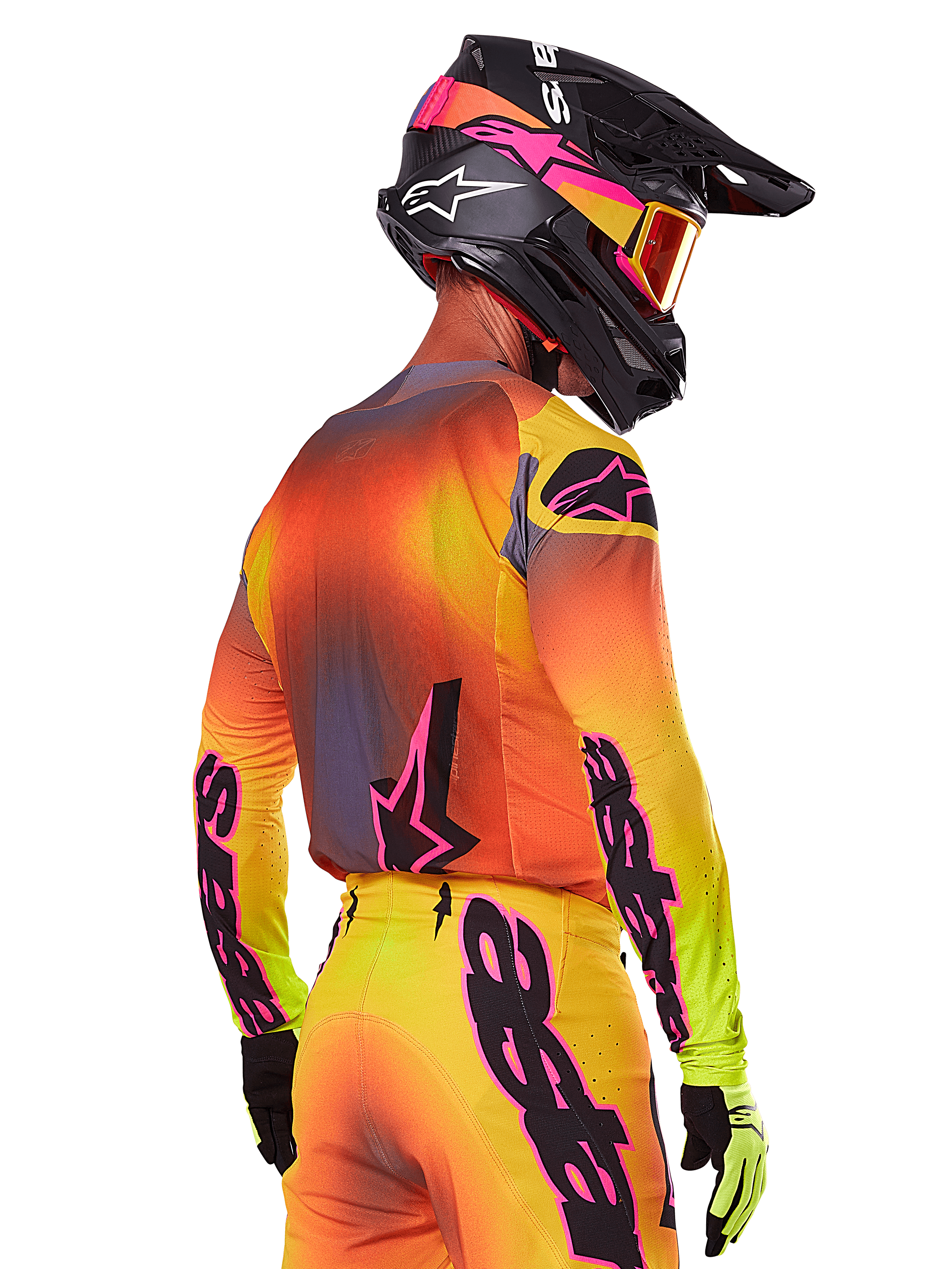 Alpinestars 2025 Supertech Lipan Gear Set, motorcrosser van achteren en opzij gezien, geel, oranje en rood kleurverloop met zwarte en roze branding, zwarte helm met roze accenten en oranje bril, professionele off-road race-uitrusting