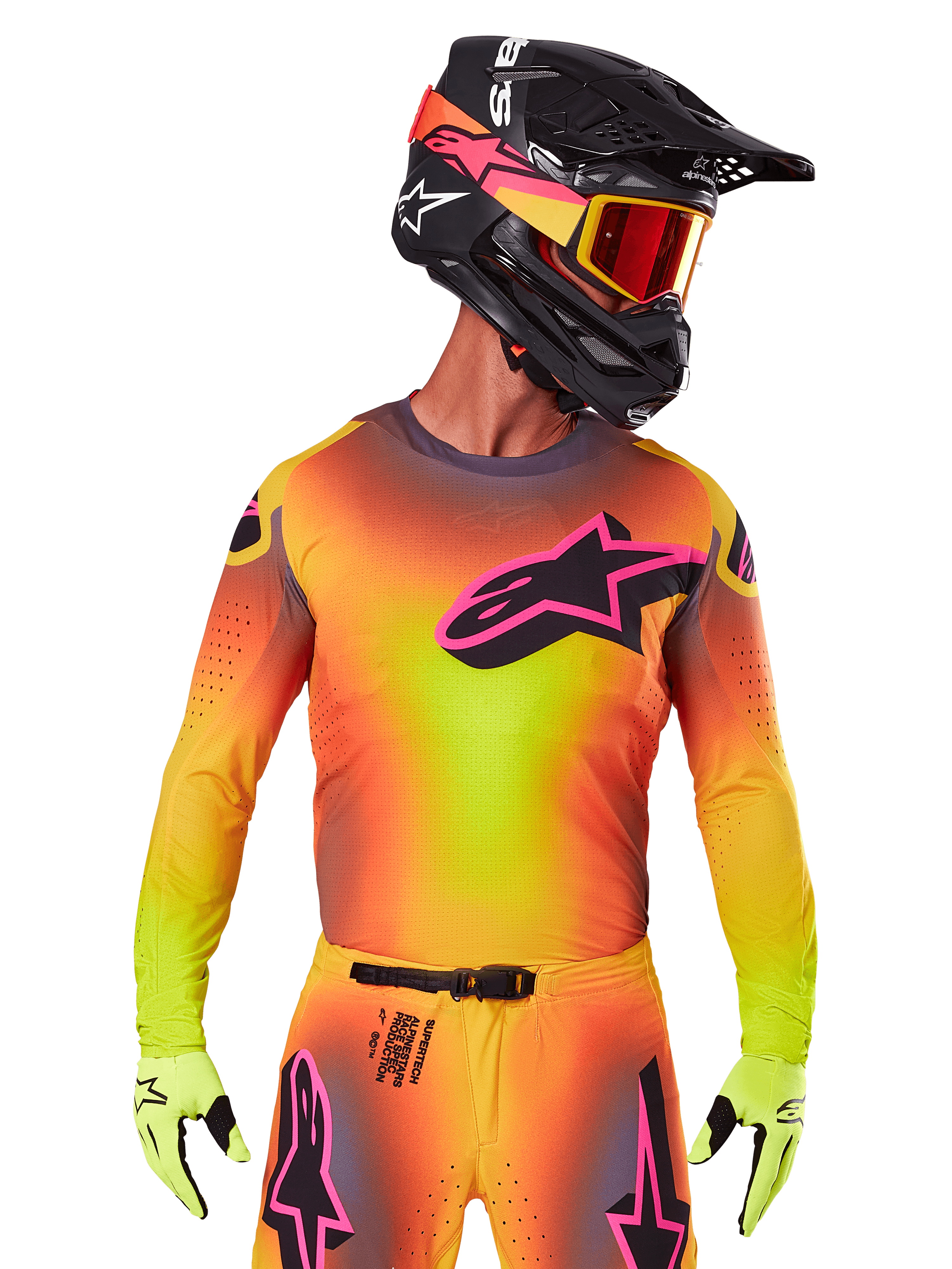 Motocrossrijder in de 2025 Supertech Lipan Jersey, levendig geel, oranje en roze kleurverloop, groot zwart Alpinestars sterlogo met roze omtrek op de borst, lasergesneden perforaties voor ventilatie, atletische racepasvorm, gecombineerd met bijpassende broek, gele handschoenen en een zwarte helm met crossbril.