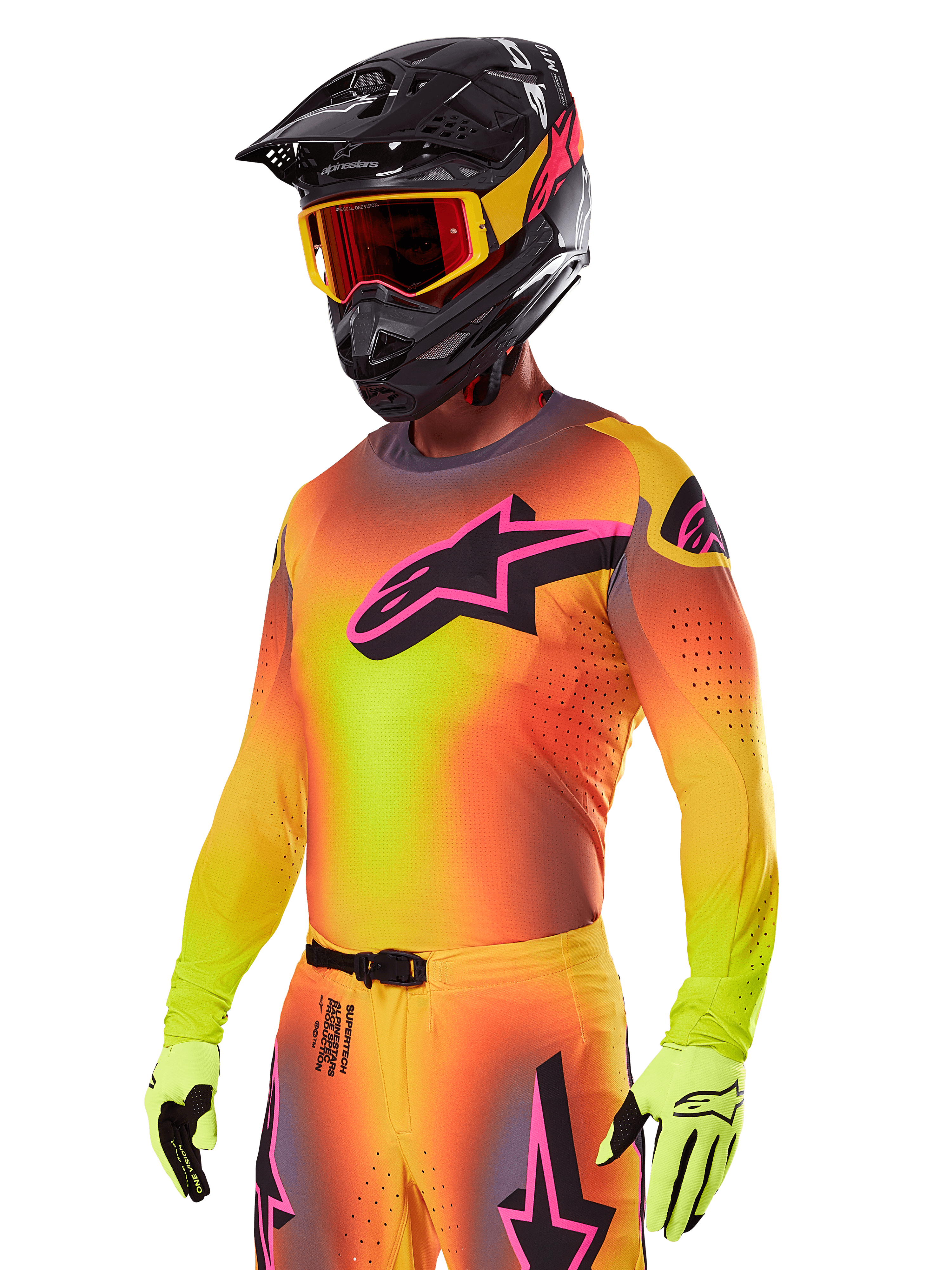 Motocrossrijder in de Alpinestars 2025 Supertech Lipan Gear Set, met een geel en oranje kleurverloop jersey met een roze en zwart Astars-logo, neongele handschoenen en een zwarte helm met rode crossbril, professionele off-road race-uitrusting.
