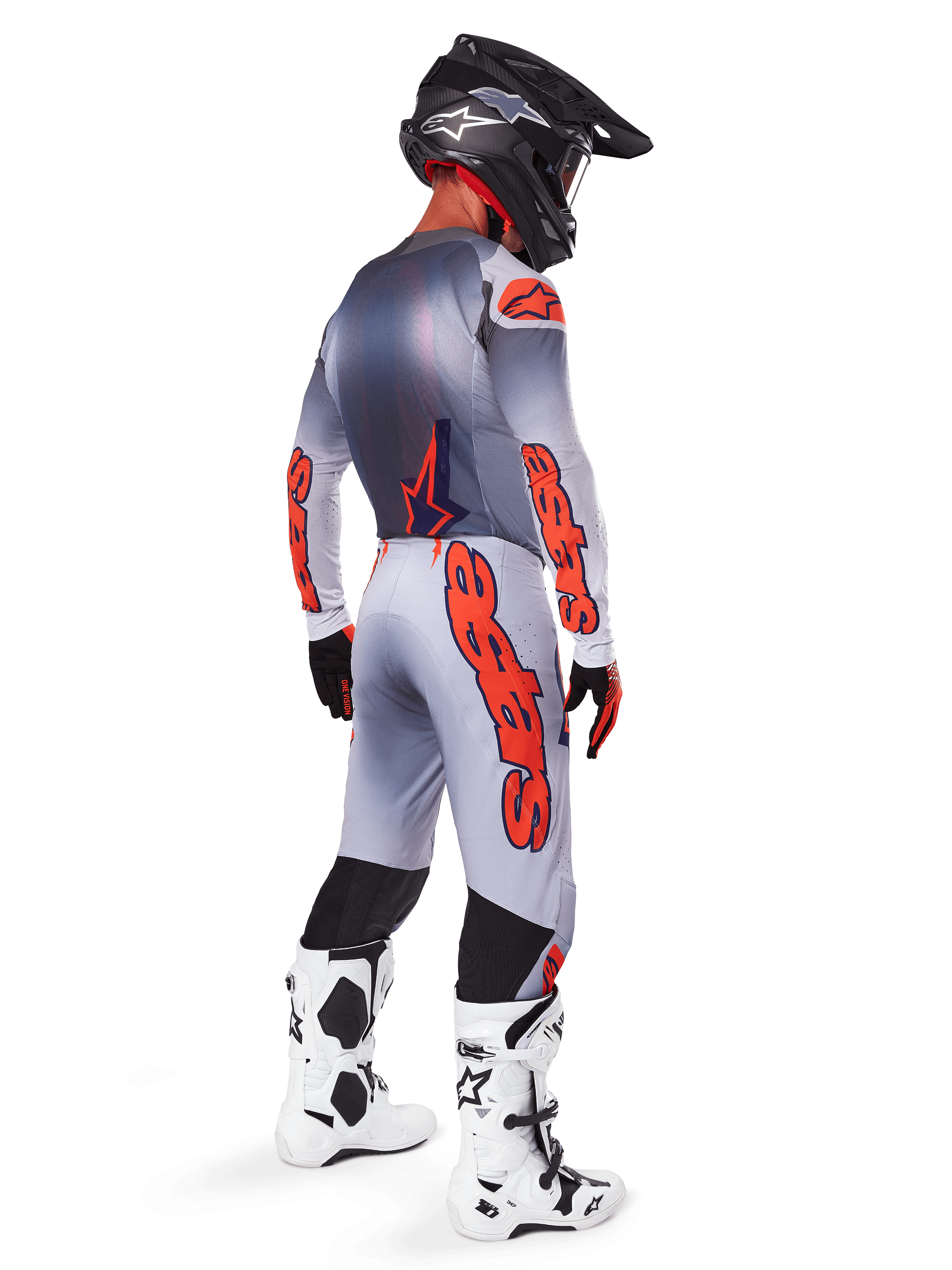 Alpinestars 2025 Supertech Lipan Jersey en bijpassende broek, motorcross outfit in grijs en fluo oranje, opvallende oranje branding op de mouwen en benen, zwarte helm en witte laarzen, professionele uitrusting voor off-road racing vanuit een zij-achterprofiel