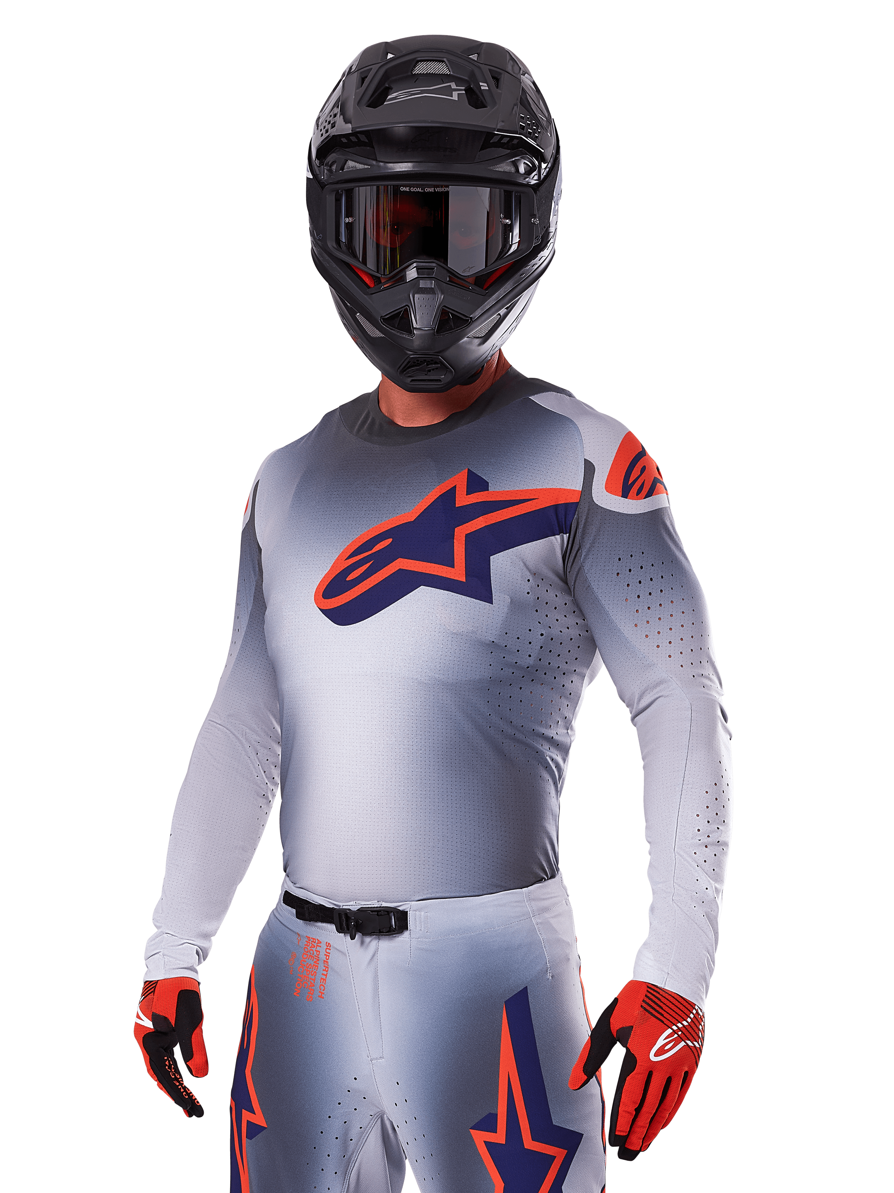 Motorcrosser in Alpinestars 2025 Supertech Lipan Gear Set, grijze jersey en broek met marineblauwe en oranje accenten, matzwarte helm met crossbril en rood-zwarte handschoenen, atletische prestatiekleding voor off-road racen
