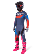 Alpinestars 2025 Techstar Dreem motorcrossuitrusting, complete off-road race-outfit met een grijs en blauw jersey met rode accenten, bijpassende broek met roze accenten, zwarte helm, felroze laarzen en wit-zwarte handschoenen