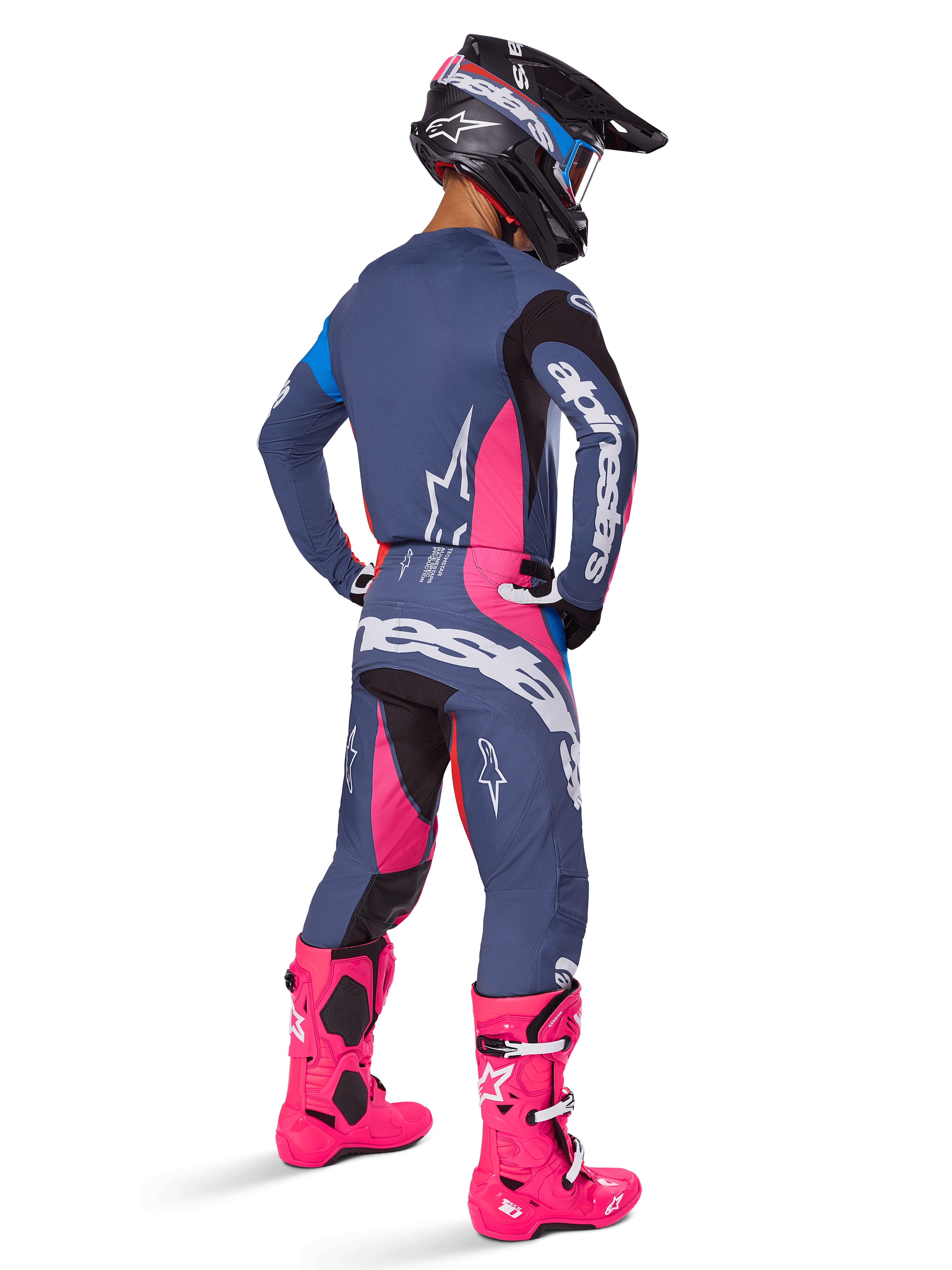 Alpinestars 2025 Techstar Dreem gear set, motorcrosser van achteren gezien, grijs met levendige roze en witte accenten, zwart-witte helm en felroze laarzen, complete race-outfit voor motorcrossprestaties.
