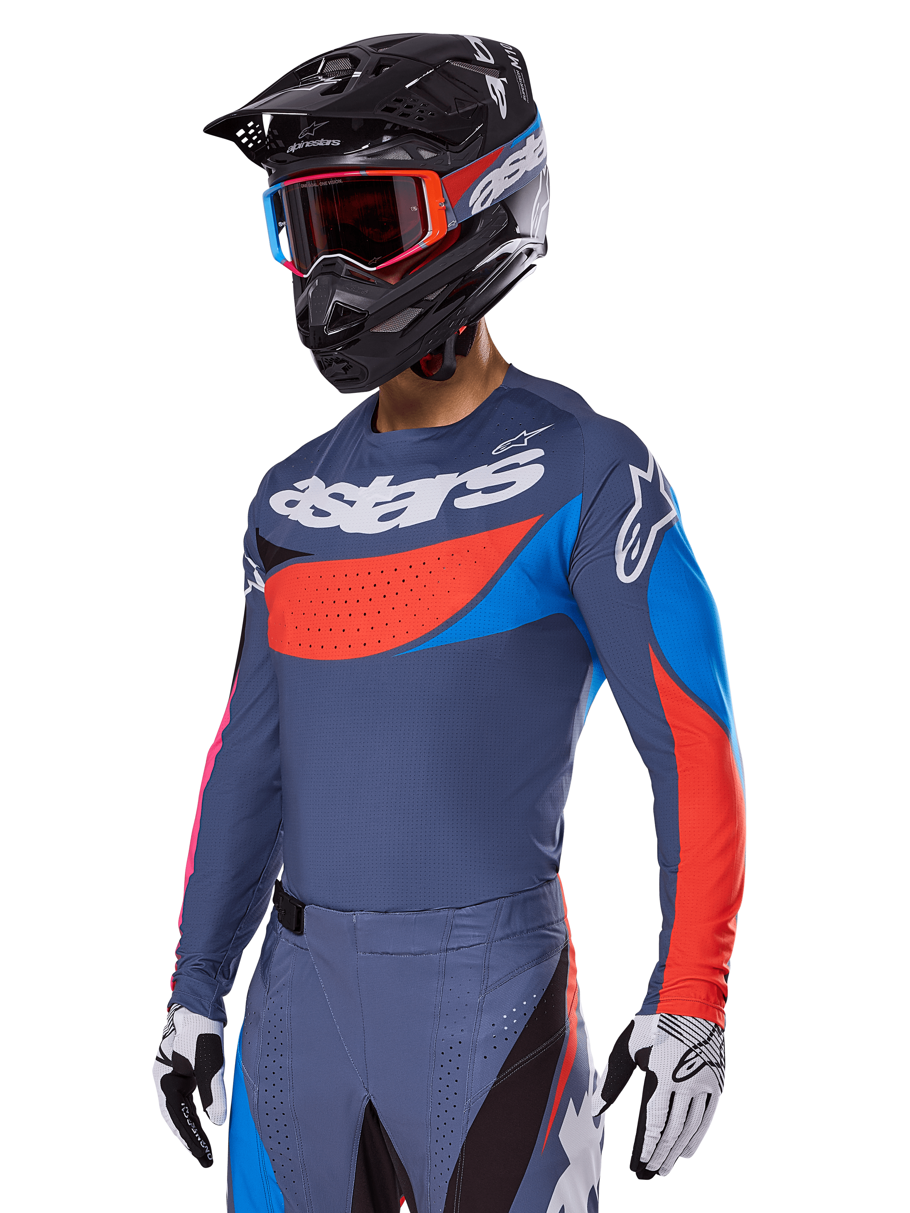 Alpinestars 2025 Techstar Dreem gear set, motorcrosser in leigrijze jersey en broek met opvallende rode en blauwe graphics, voorzien van 'astars'-branding op de borst, gecombineerd met een zwarte helm, crossbril met rood montuur en witte racehandschoenen