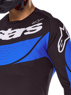 Alpinestars Techstar Dreem jersey en kledingset 2025, zwart-blauwe geventileerde motorcrosstop met lasergesneden perforaties.