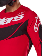Alpinestars 2025 Techstar Dreem Jersey, motorcross jersey, felrood en zwart, close-up van borst en schouder met witte logo's, zwarte diagonale panelen met lasergesneden perforaties voor ventilatie, atletische racepasvorm voor off-road prestaties