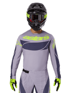 2025 Techstar Dreem Jersey en Gear Set, motorcross racetenue, lichtgrijs en donkergrijs met neongele accenten, voorzien van 'astars' branding, gedragen met zwarte helm, bril en bijpassende handschoenen, technisch geperforeerd materiaal voor off-road prestaties