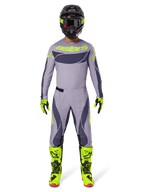 Motorcrossrijder in volledige race-uitrusting, 2025 Techstar Dreem Jersey in grijs en donkergrijs met neongele branding, bijpassende grijze en donkergrijze broek, neongele en zwarte laarzen, zwarte helm met neonaccenten, gecoördineerde outfit voor professionele motorcross