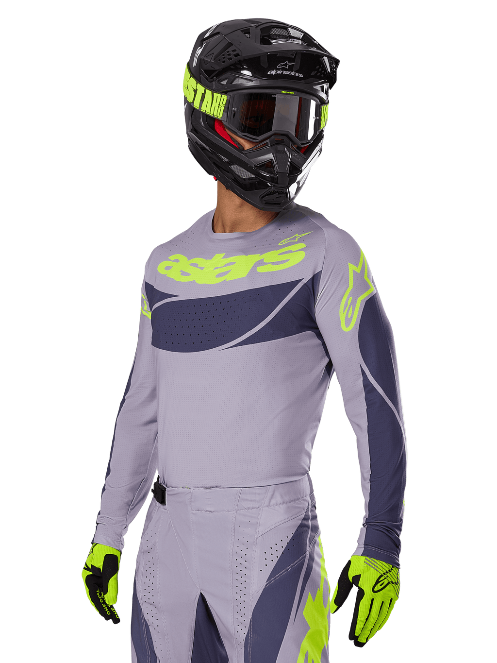 Motorcrossrijder in Alpinestars 2025 Techstar Dreem Jersey, grijs en donkergrijs met limegroene logo's, bijpassende broek, zwarte helm met limegroene accenten, limegroene en zwarte handschoenen, gecoördineerde outfit voor off-road racing