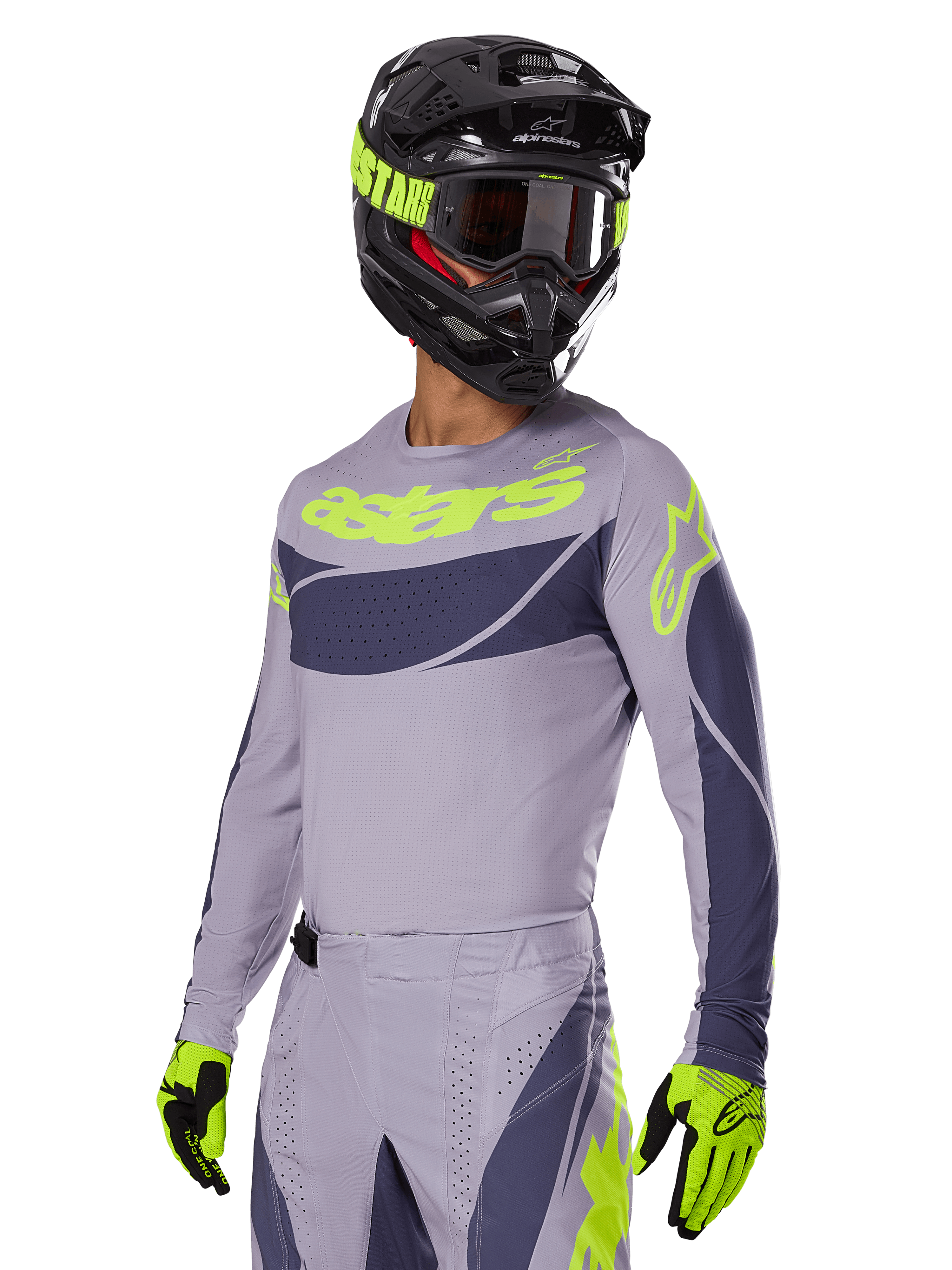 Motorcrossrijder in Alpinestars 2025 Techstar Dreem Jersey, grijs en donkergrijs met limegroene logo's, bijpassende broek, zwarte helm met limegroene accenten, limegroene en zwarte handschoenen, gecoördineerde outfit voor off-road racing