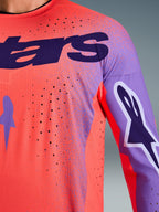 Alpinestars 2026 Supertech Scenz Jersey, Motocross Jersey, Hot Coral and Purple, close-up view showing breathable mesh texture and laser-cut perforations, featuring large purple chest logo and sleeve graphics for professional off-road racing.