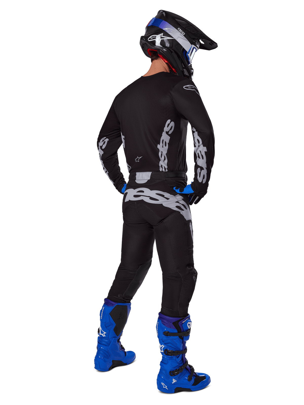 Alpinestars 2025 Racer Graphite Gear Set, motorcrossrijder van achteren gezien, zwart en grijze jersey en broek met grijze branding, helderblauwe motorcrosslaarzen, zwart-blauwe helm en blauwe handschoenen, complete performance off-road outfit