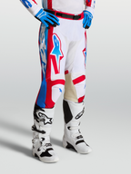 Alpinestars Racer Hunt Broek, motocrossbroek in wit, rood en blauw met voorgevormde broekspijpen en leren binnenknieën.