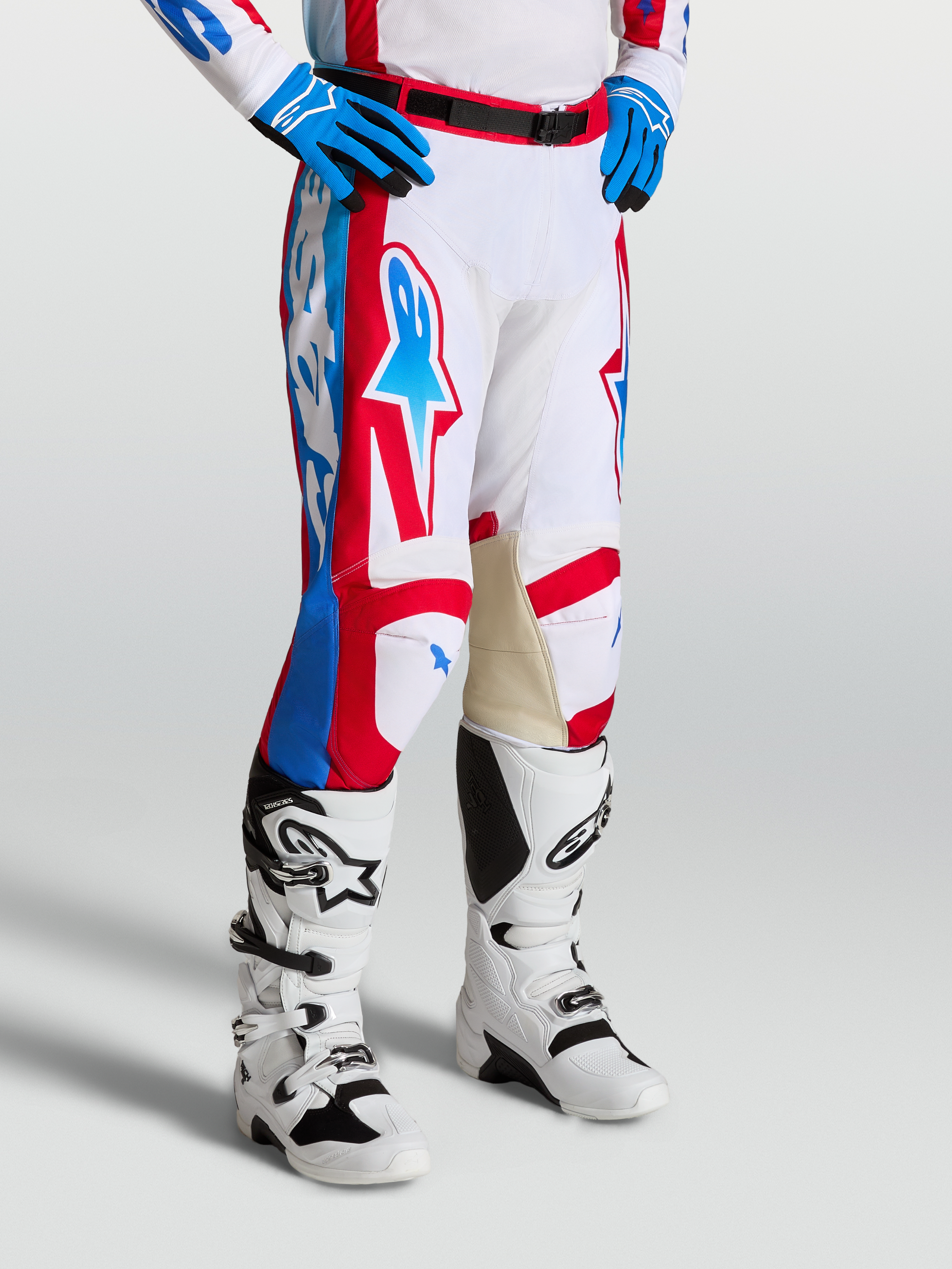Alpinestars Racer Hunt Broek, motocrossbroek in wit, rood en blauw met voorgevormde broekspijpen en leren binnenknieën.