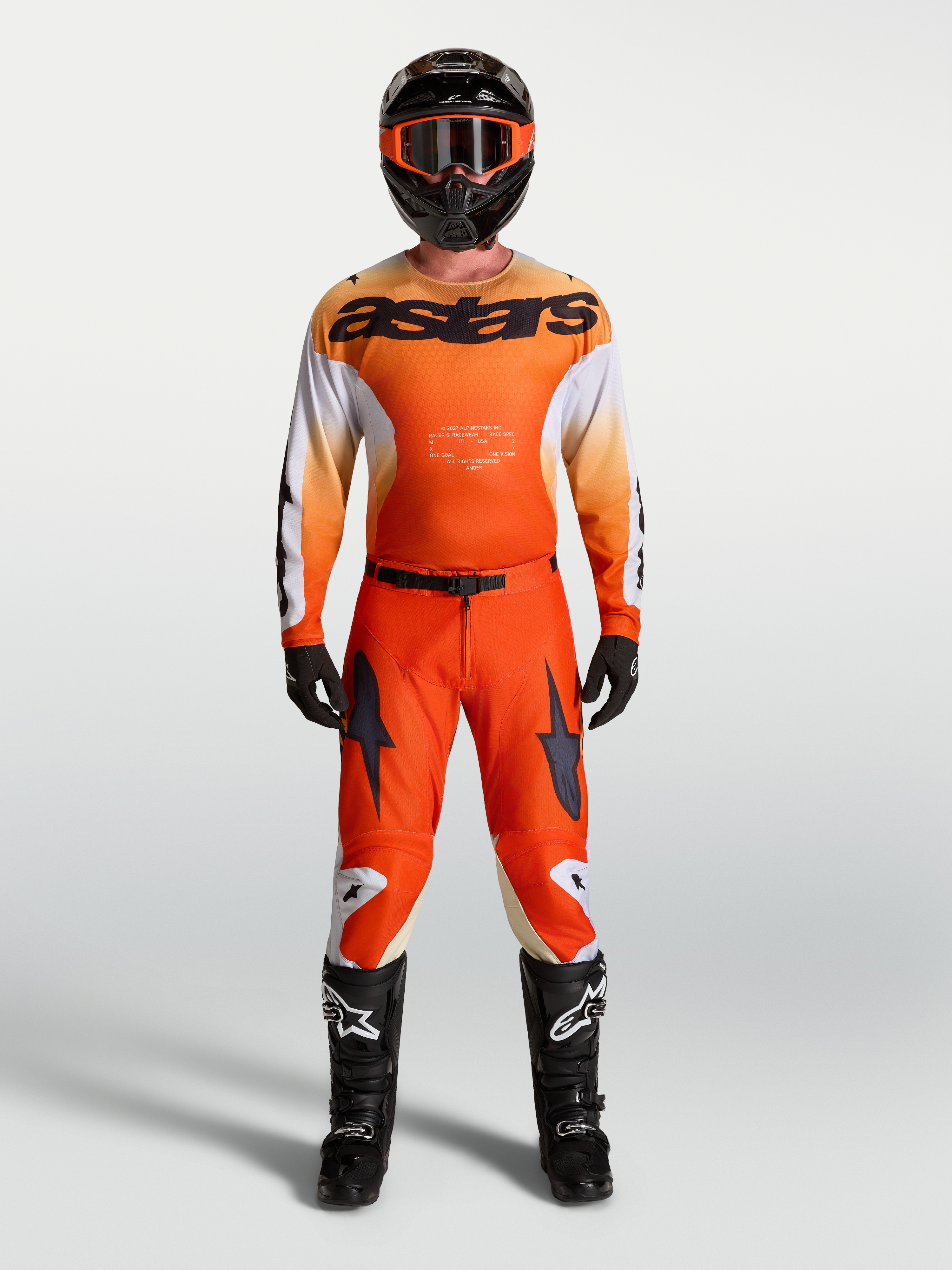 Alpinestars 2027 Racer Amber Gear Set en broek, oranje en zwarte motorcrossuitrusting voor racing, gedragen door model.