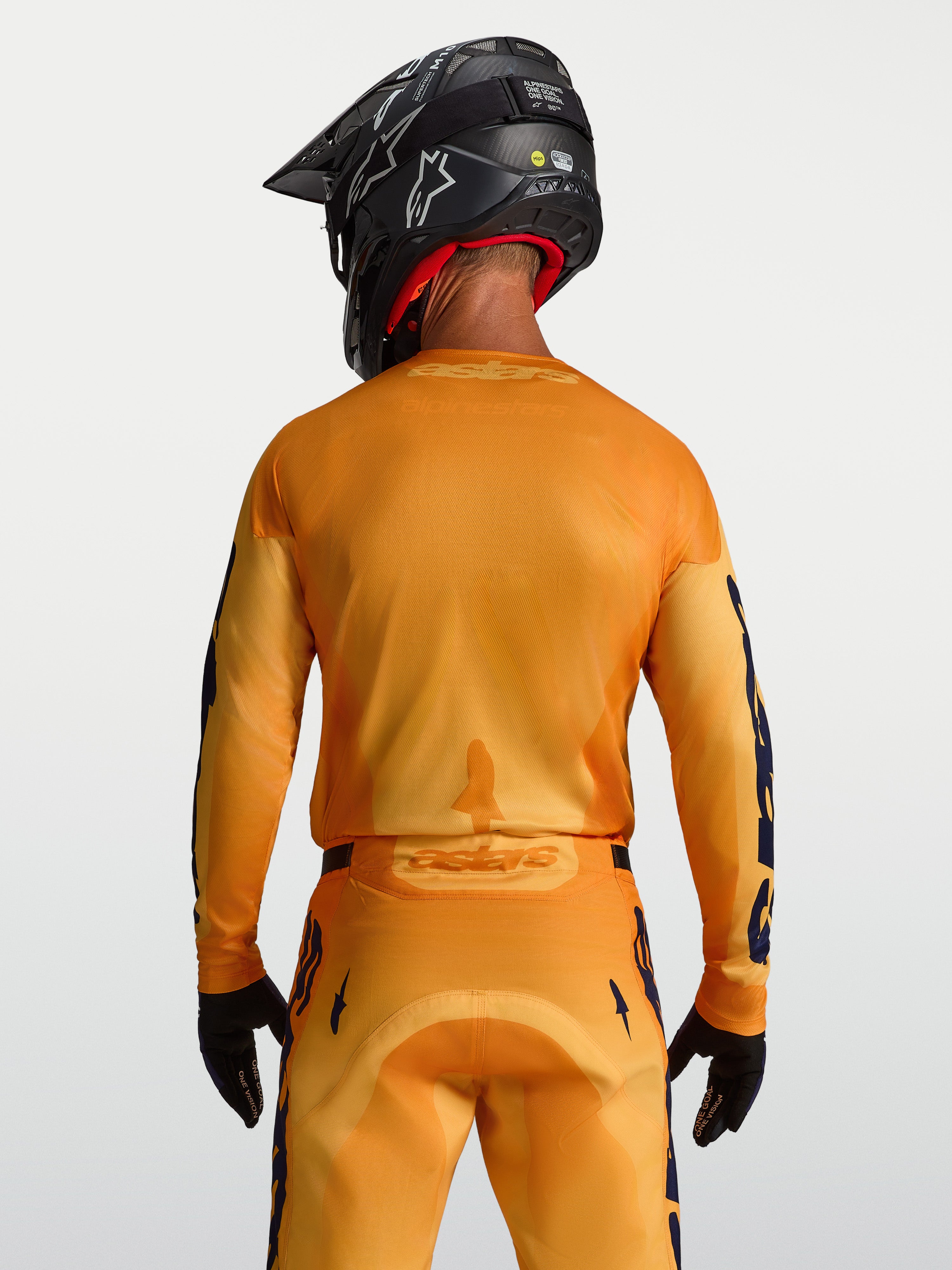 Alpinestars Racer Amber jersey, heren-motocrossjersey, oranje en goud, ademende meshpanelen, achteraanzicht op model.