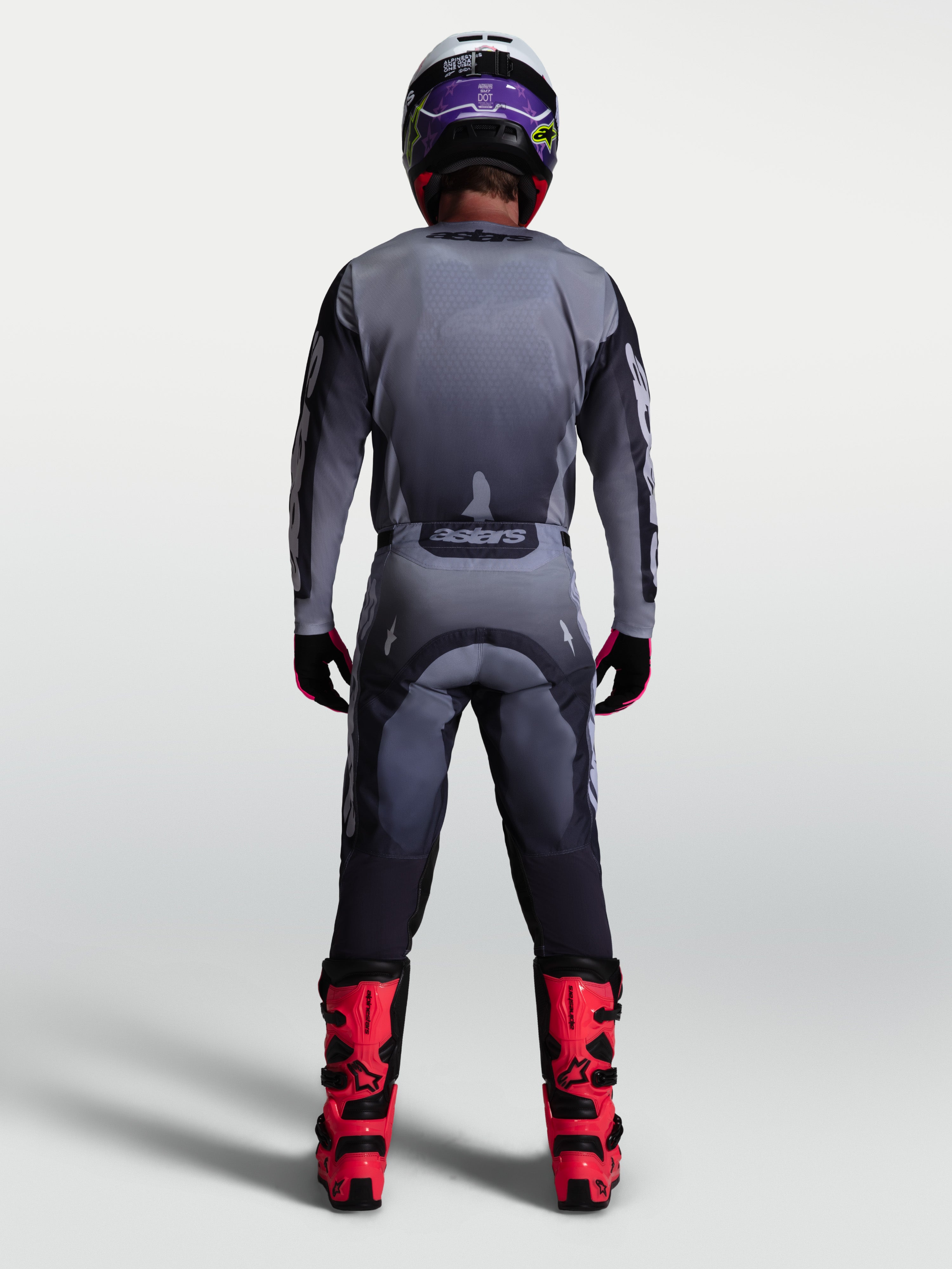 Alpinestars 2027 Racer Amber gear set, achteraanzicht van heren-motocrossjersey en -broek in grijs en lichtlila op model.