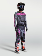 Alpinestars Racer Lone broek en jersey, heren motorcrossraceset in grijs camo en paars, gedragen door model met helm en laarzen voor een complete off-road look.