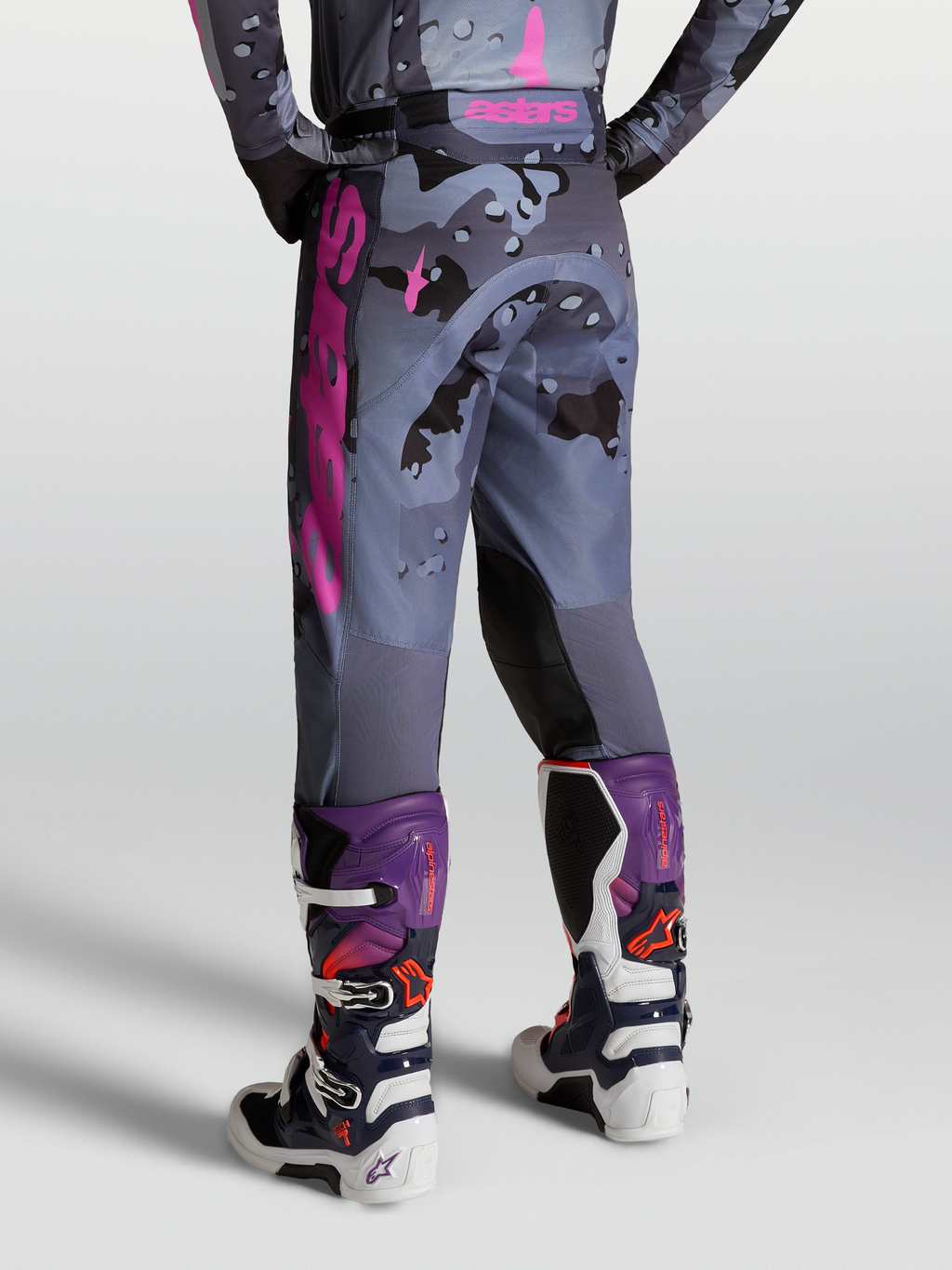 Alpinestars Racer Lone Broek, motocrossbroek in grijs camo en paars, achteraanzicht op model met Tech 7 laarzen.