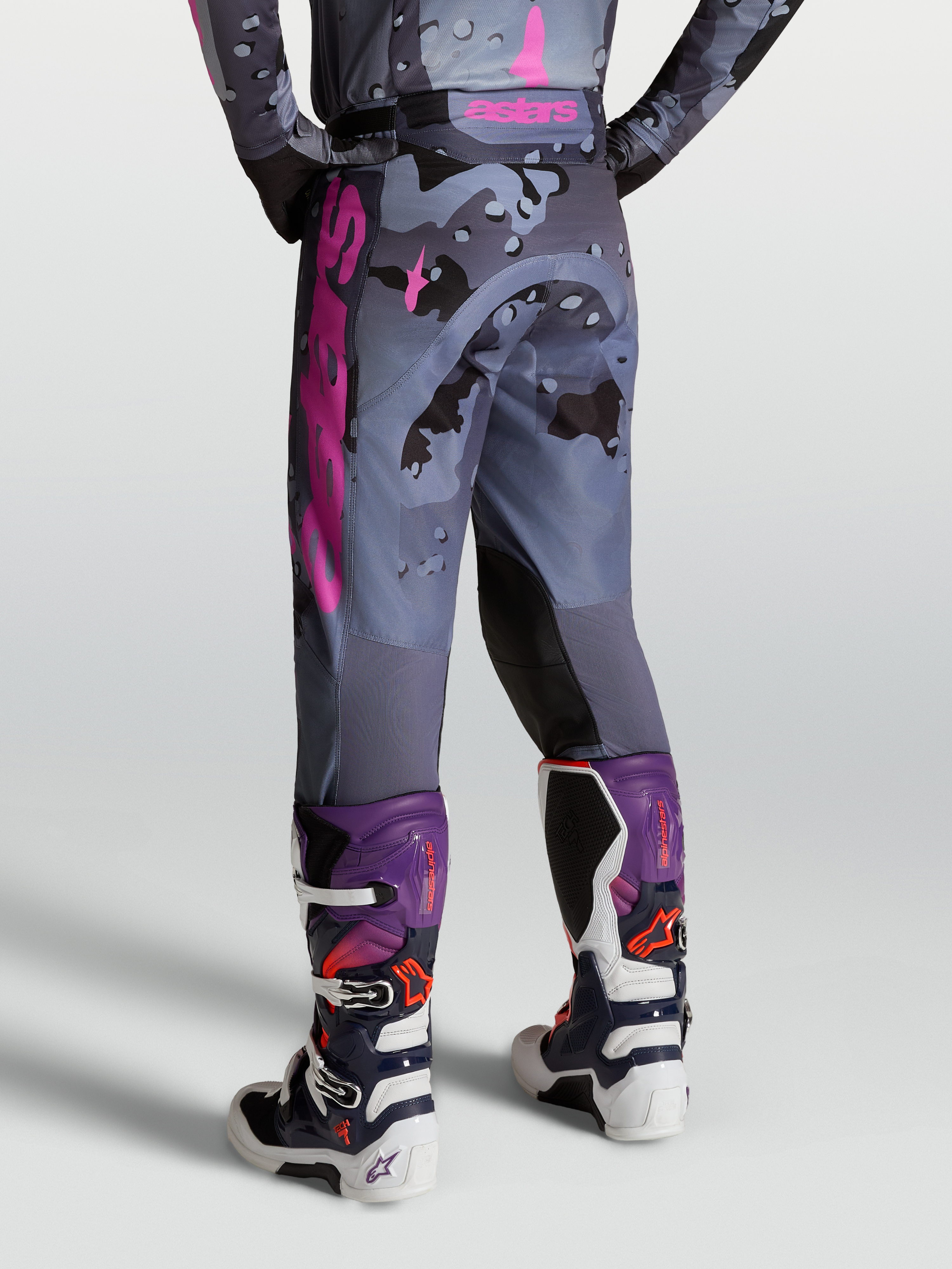 Alpinestars Racer Lone Broek, motocrossbroek in grijs camo en paars, achteraanzicht op model met Tech 7 laarzen.