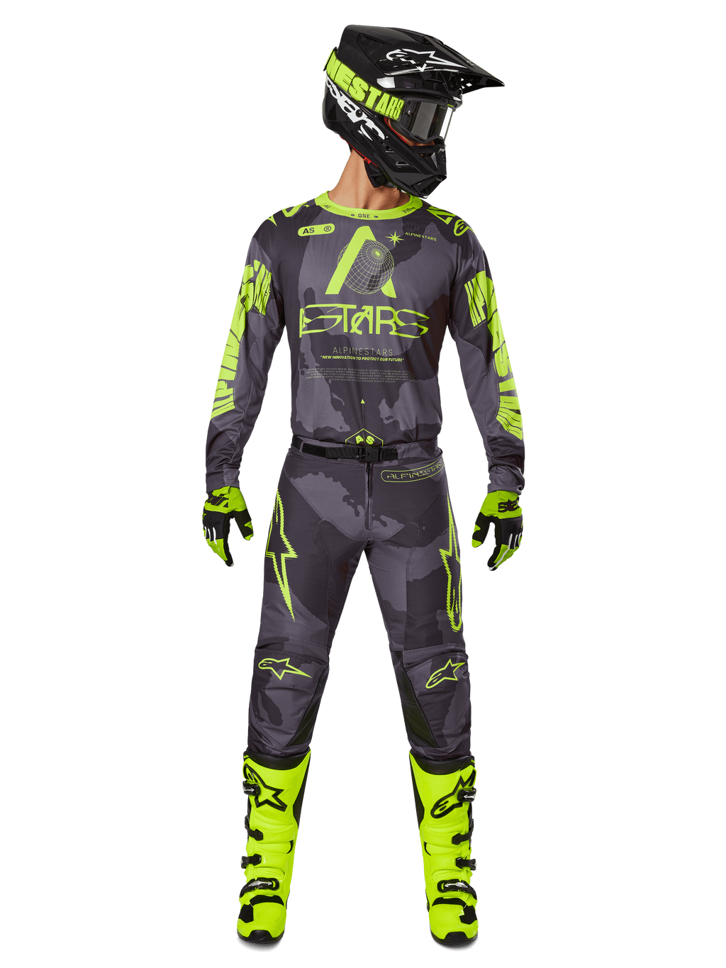 Motorcrossrijder in volledige race-uitrusting, Alpinestars 2025 Racer Hollow Jersey en bijpassende broek in Dark Camo Yellow Fluo, met opvallende fluorescerende gele graphics op een donkergrijze camouflage-achtergrond, gecombineerd met bijpassende handschoenen, felle fluogele laarzen en een zwarte helm.