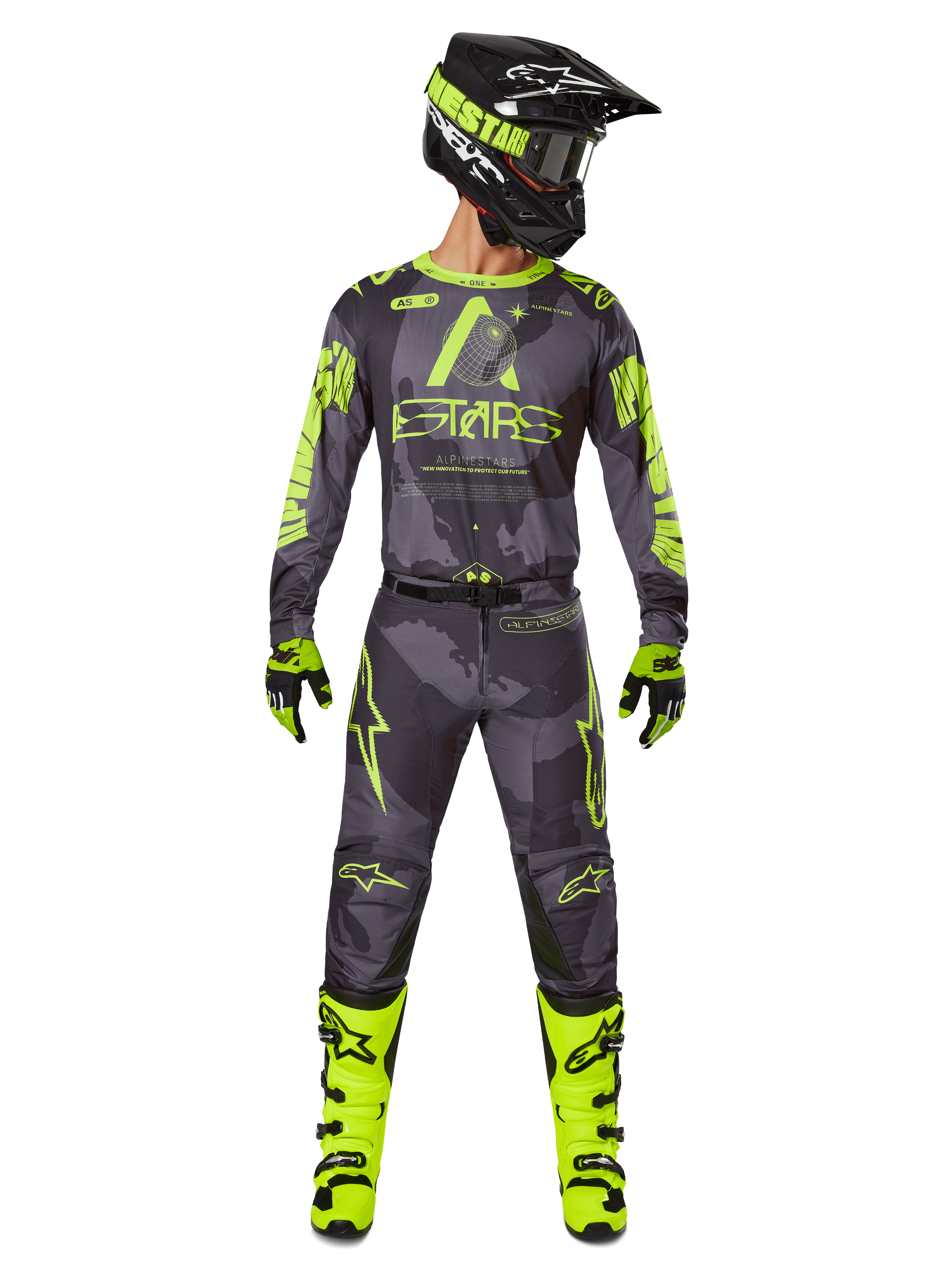 Motorcrossrijder in volledige race-uitrusting, Alpinestars 2025 Racer Hollow Jersey en bijpassende broek in Dark Camo Yellow Fluo, met opvallende fluorescerende gele graphics op een donkergrijze camouflage-achtergrond, gecombineerd met bijpassende handschoenen, felle fluogele laarzen en een zwarte helm.