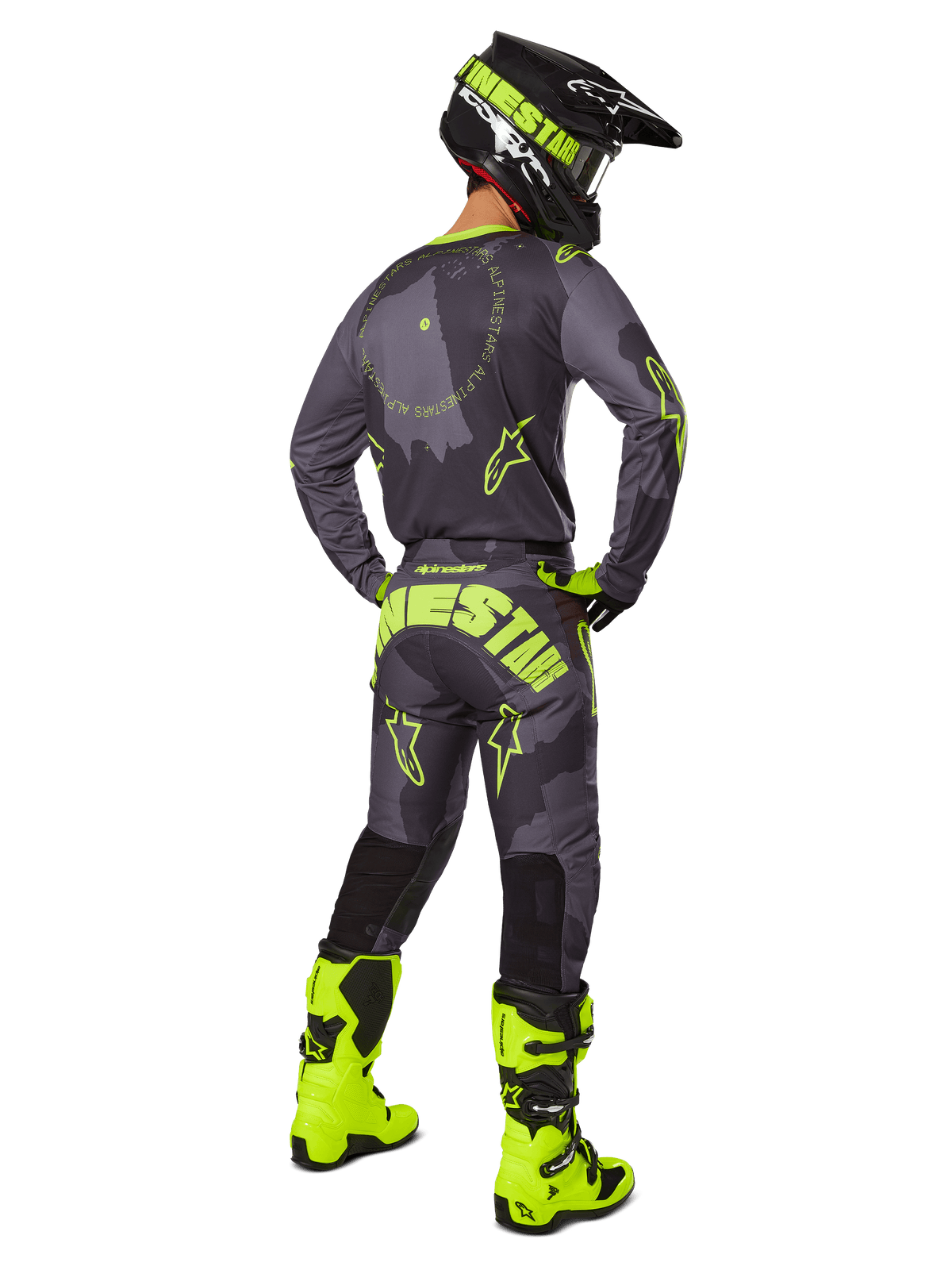 Achteraanzicht van een motorcrosser die de 2025 Racer Hollow Gear Set draagt in Dark Camo Yellow Fluo, voorzien van een grijs camo jersey met geel fluo accenten, bijpassende motorcrossbroek met opvallende branding op het zitvlak, felgele fluo laarzen en een zwarte helm met gele bril.