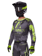 Alpinestars 2025 Racer Hollow Gear Set, Motocross jersey and pants in Gray and Neon Yellow, worn with matching black helmet, goggles, and gloves, featuring bold fluorescent yellow Alpinestars branding and star graphics on a patterned gray base, coordinated professional off-road racing look