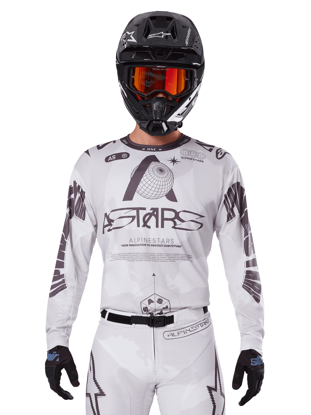 Alpinestars 2025 Racer Hollow Jersey, motocross jersey, wit en zwart, gedragen met een bijpassende witte MX-broek en een zwarte helm met oranje crossbril, voorzien van opvallende Alpinestars-branding en wereldbol-graphics, professionele off-road race-uitrusting
