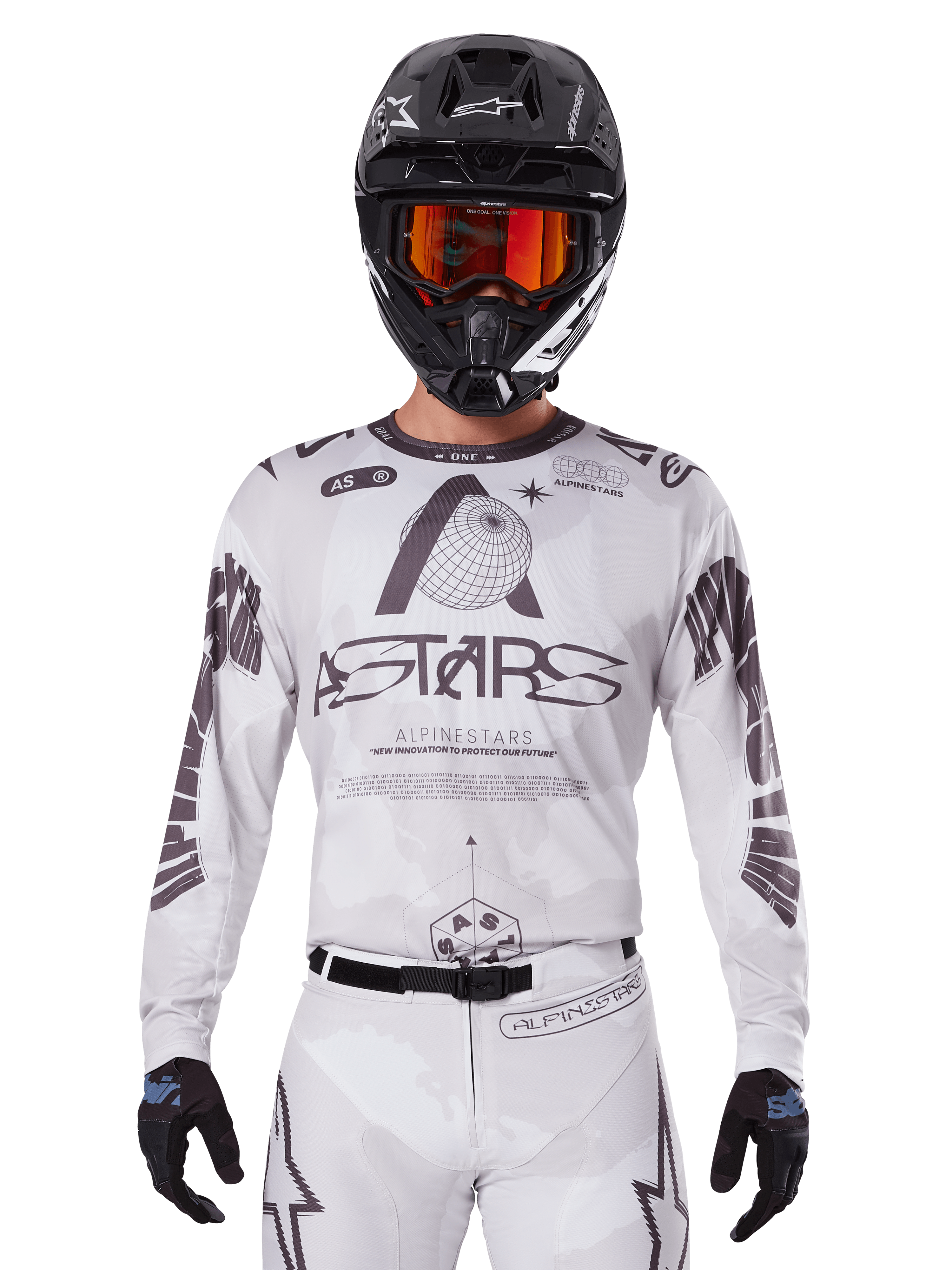 Alpinestars 2025 Racer Hollow Jersey, motocross jersey, wit en zwart, gedragen met een bijpassende witte MX-broek en een zwarte helm met oranje crossbril, voorzien van opvallende Alpinestars-branding en wereldbol-graphics, professionele off-road race-uitrusting