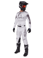 Alpinestars 2025 Racer Hollow Gear Set, motorcross outfit, wit en grijs, jersey en broek met opvallende 'STARS' branding, zwarte helm met oranje-rood getinte bril, zwarte handschoenen en laarzen, complete professionele uitrusting voor motorcross