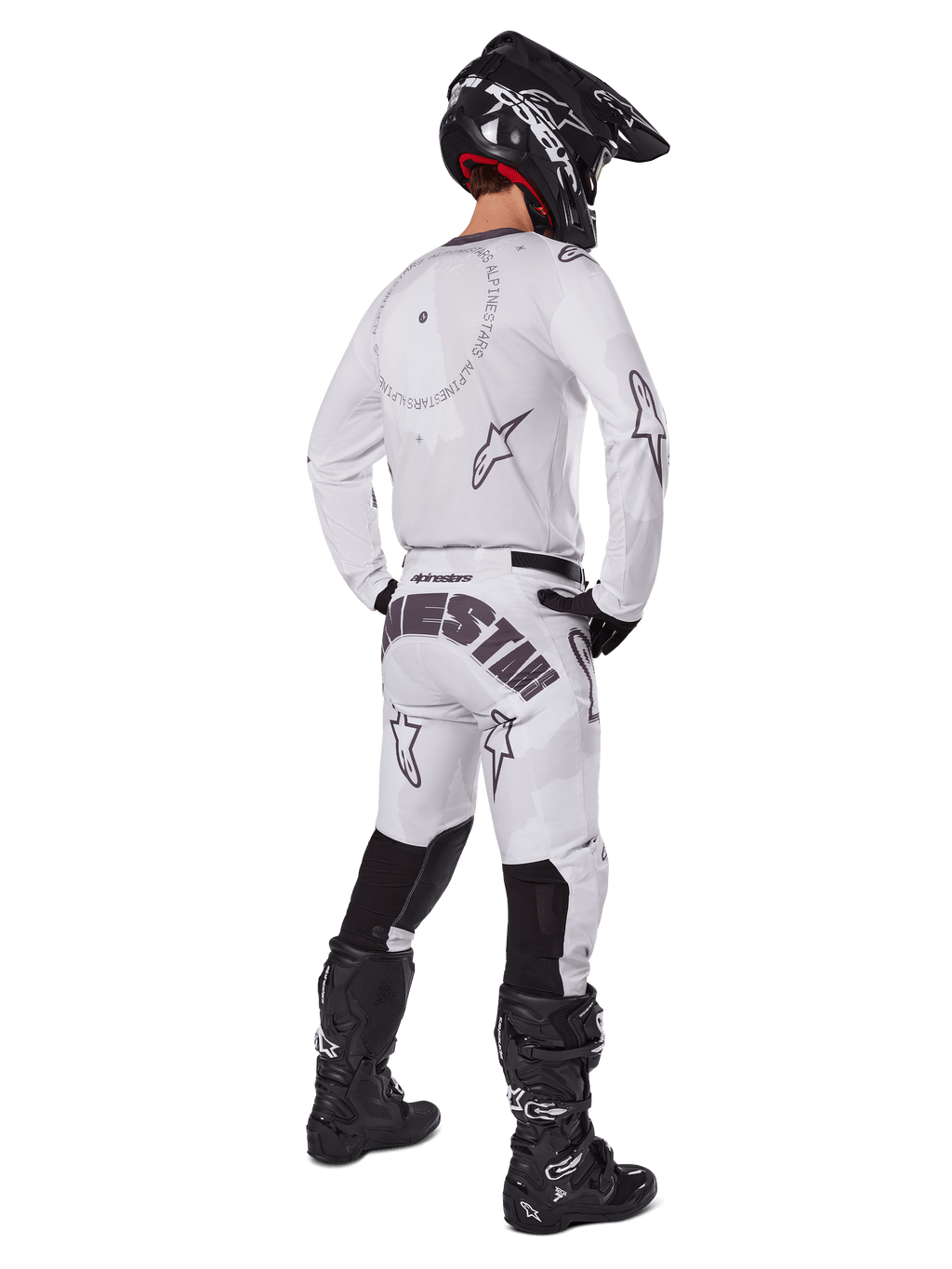 Alpinestars 2025 Racer Hollow Gear Set, wit, achteraanzicht van een motorcrosser met wit shirt en broek, zwarte logo's, zwarte helm en zwarte laarzen, professionele off-road race-outfit