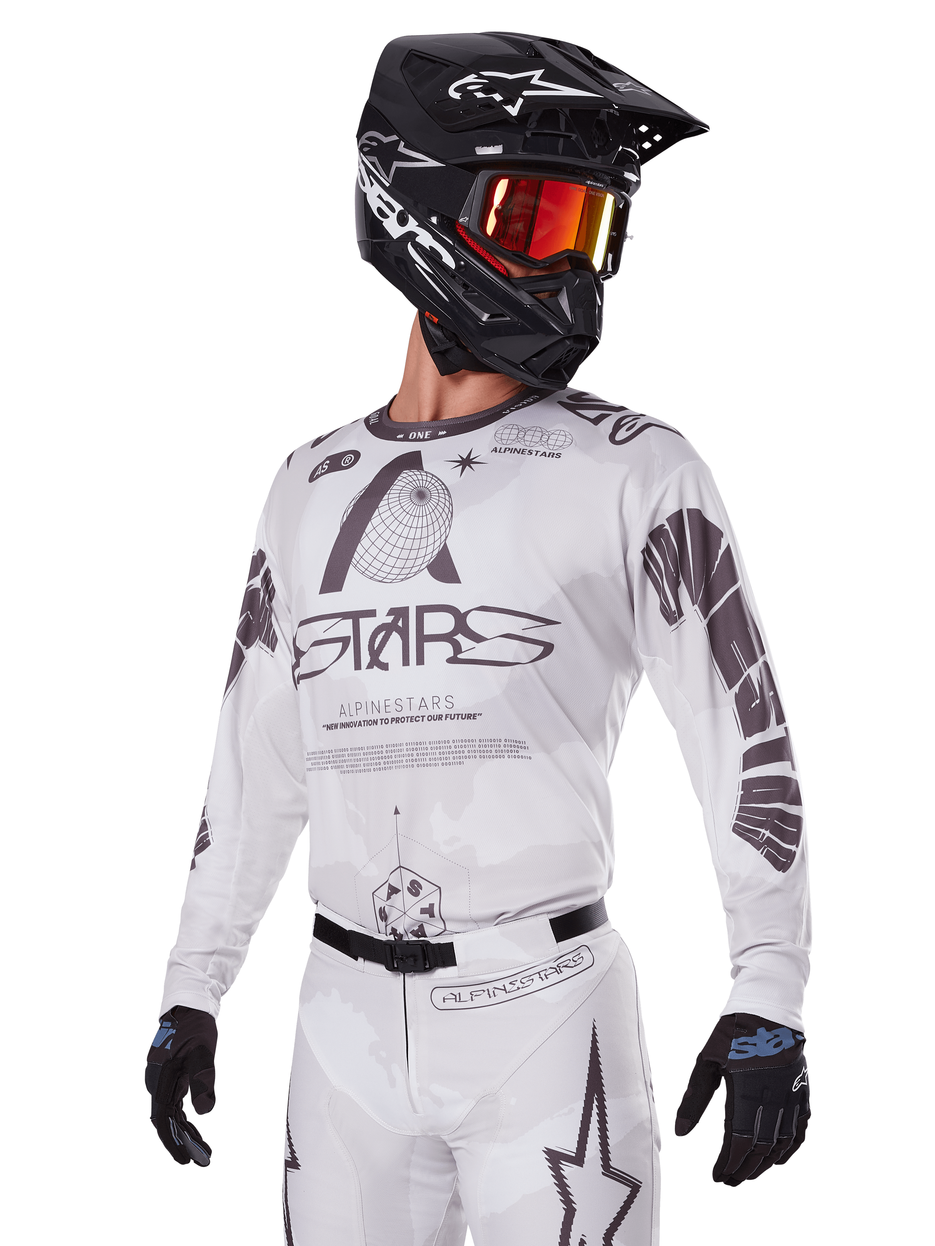 Alpinestars 2025 Racer Hollow Gear Set, motorcross jersey en broek, wit met zwarte en grijze graphics, voorzien van 'ASTARS' branding en hollow globe ontwerpen, gedragen met een zwarte helm, rode spiegelbril en zwarte handschoenen, ontworpen voor off-road prestaties