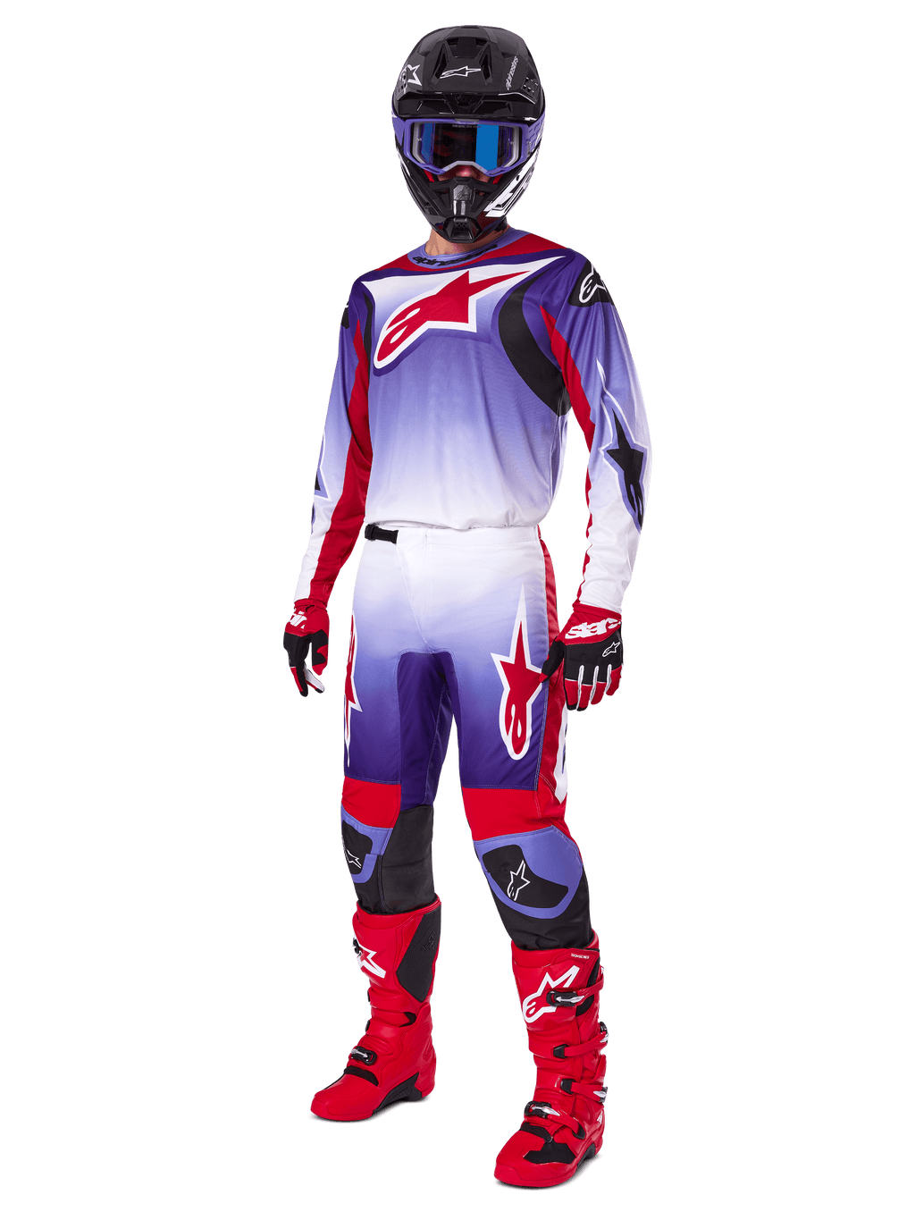 Motorcrosser in de Alpinestars 2025 Fluid Wurx Gear Set, paars en felrood jersey met witte accenten, bijpassende motorcrossbroek, felrode laarzen, zwarte helm met blauwe bril en rode en zwarte handschoenen, volledige professionele off-road race-uitrusting