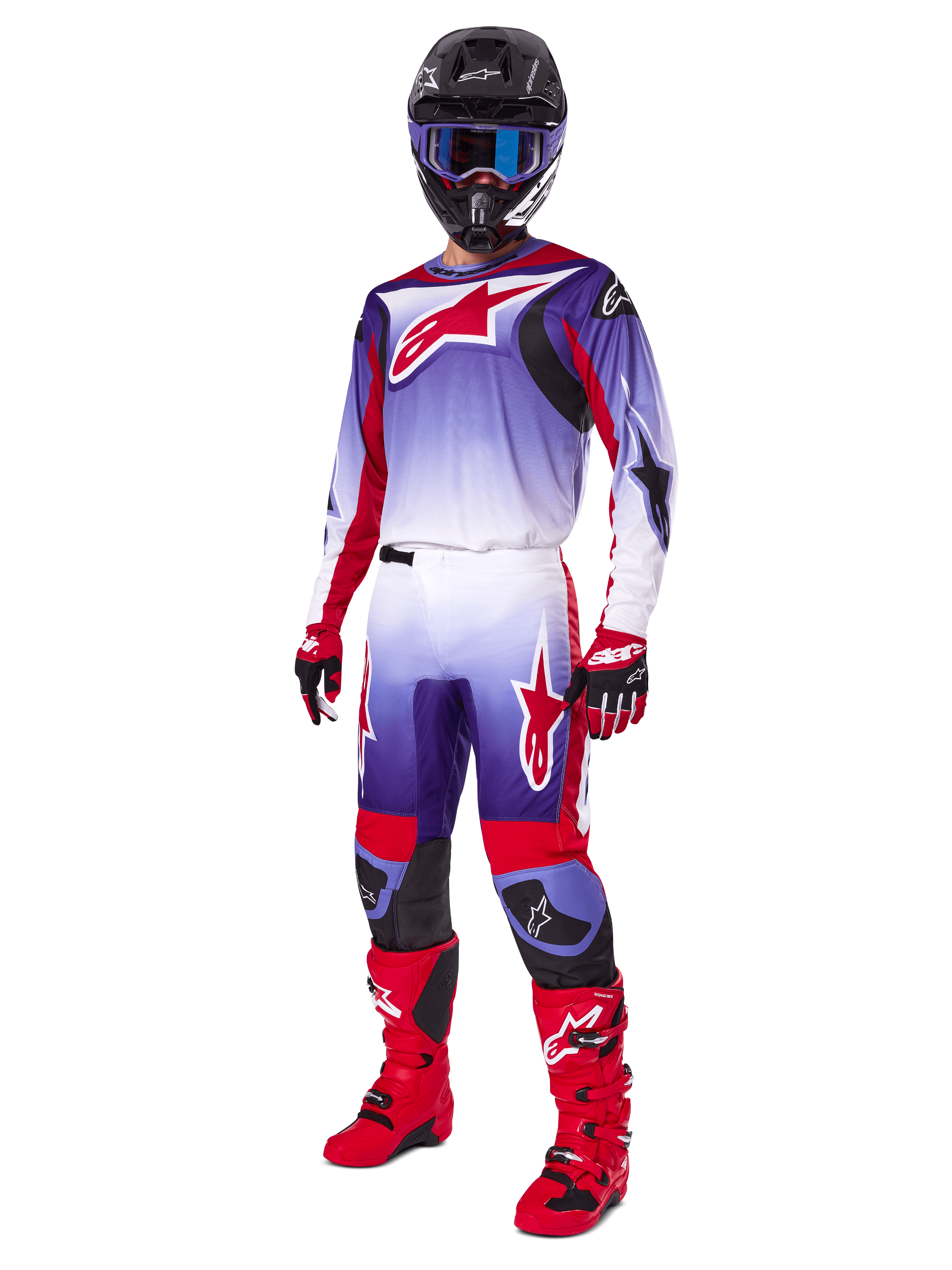 Motorcrosser in de Alpinestars 2025 Fluid Wurx Gear Set, paars en felrood jersey met witte accenten, bijpassende motorcrossbroek, felrode laarzen, zwarte helm met blauwe bril en rode en zwarte handschoenen, volledige professionele off-road race-uitrusting
