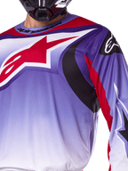 Alpinestars 2025 Fluid Wurx Jersey, motocross jersey, paars en felrood, close-up van rijder die de jersey draagt met groot rood Alpinestars ster-logo op de borst, zwarte en rode gebogen grafische accenten, atletische pasvorm voor off-road racen