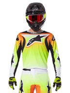 Alpinestars 2025 Fluid Wurx Jersey, motorcross jersey, neongeel, oranje en wit, gedragen met bijpassende broek en zwarte helm met rode bril, complete MX-uitrusting op de rijder