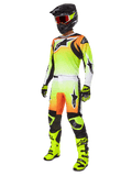 Alpinestars 2025 Fluid Wurx Gear Set, motorcross race-outfit, neongeel en oranje kleurverloop, complete set met jersey en broek, zwarte helm met oranje bril, neongele laarzen en handschoenen, atletisch ontwerp voor off-road prestaties