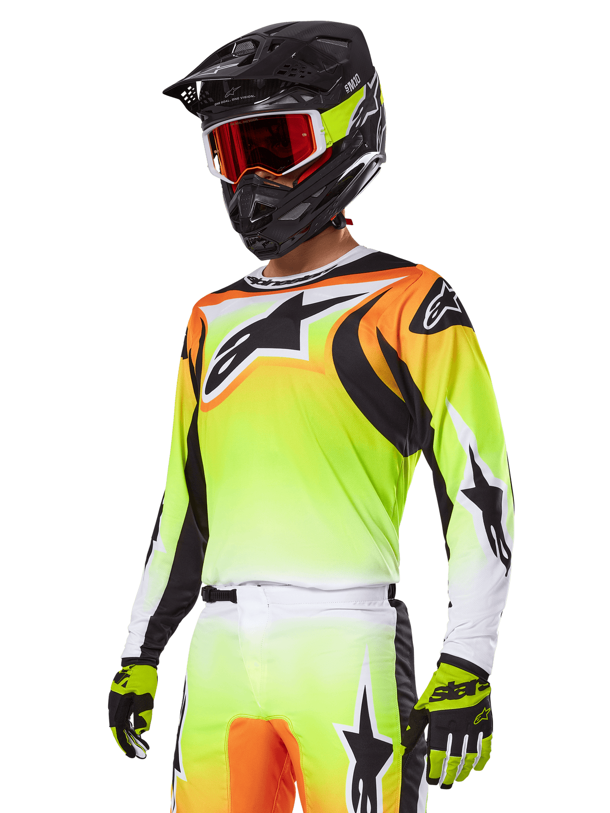 Motocross-rijder in Alpinestars 2025 Fluid Wurx Gear Set, jersey met geel en oranje kleurverloop, zwarte accenten en grote sterlogo's, bijpassende motorcrossbroek, zwarte full-face helm met rood getinte bril en gele handschoenen, gecoördineerde high-performance outfit voor off-road racen