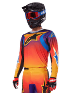 Alpinestars 2025 Fluid Wurx gearset, motorcross set, oranje, paars en blauw kleurverloop, voorzien van een groot zwart A-stars logo, gedragen met een zwarte helm en blauwe bril, gecoördineerde outfit voor professioneel off-road racen