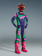 Motocross rider wearing the Alpinestars 2026 Techstar Nomur Gear Set in Deep Purple, Green, and Pink Fluo, featuring a matching jersey and pants, a colorful helmet with pink goggles, and vibrant pink boots, professional off-road racing equipment.