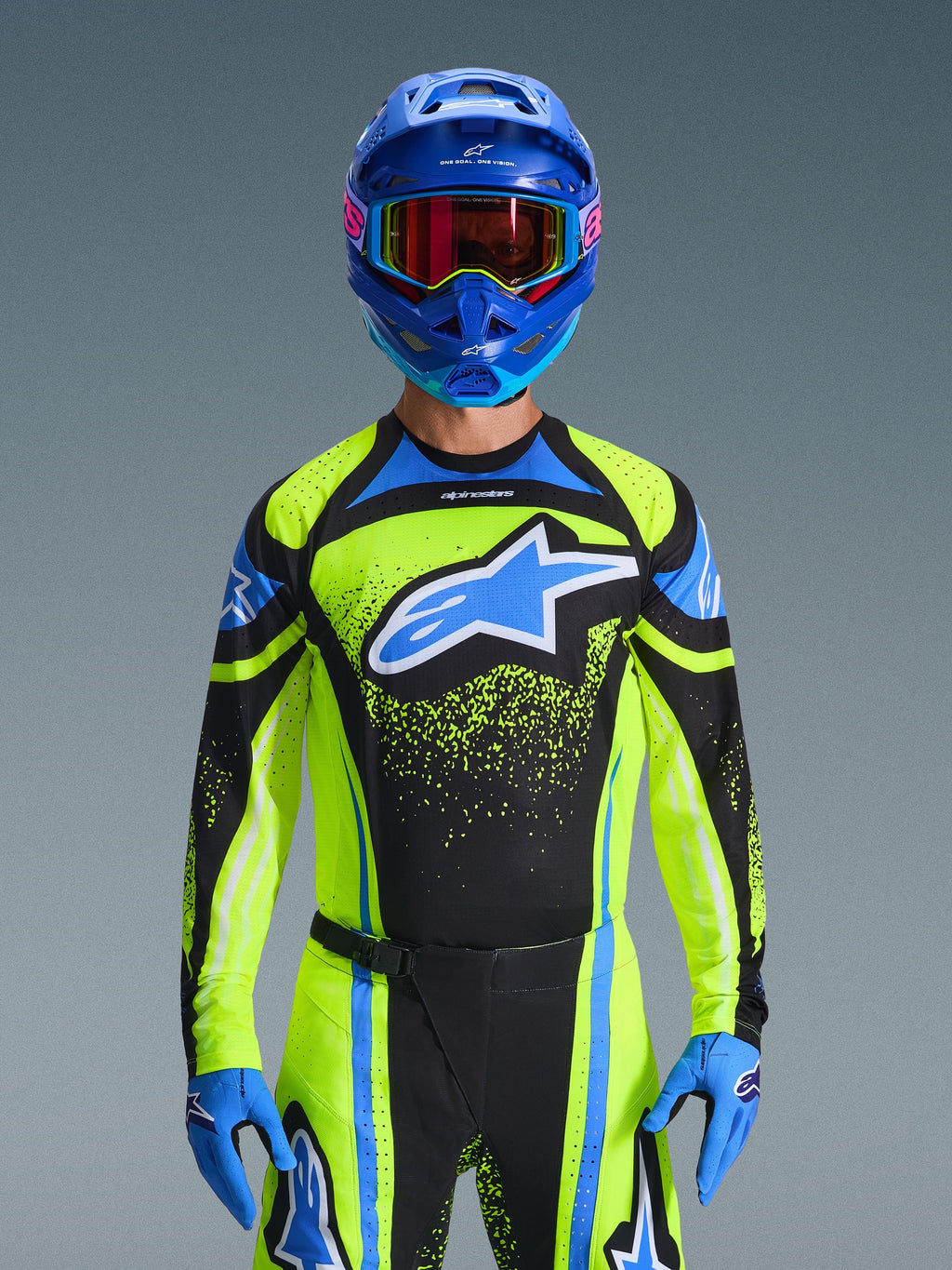 Motorcrosser draagt de Alpinestars 2026 Techstar Nomur Jersey in Dark Navy en Yellow Fluo met blauwe accenten, voorzien van een groot blauw logo op de borst, bijpassende blauwe helm en bril, gecoördineerde race-uitrusting voor off-road competitie