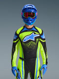 Motorcrosser draagt de Alpinestars 2026 Techstar Nomur Jersey in Dark Navy en Yellow Fluo met blauwe accenten, voorzien van een groot blauw logo op de borst, bijpassende blauwe helm en bril, gecoördineerde race-uitrusting voor off-road competitie